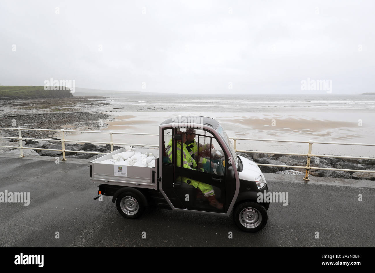 Members of Clare County council deliver sandbags on the sea front in Lahinch, County Clare, on the West Coast of Ireland in preparation for storm Lorenzo, as a status orange wind warning and a yellow rain warning have been issued. Stock Photo