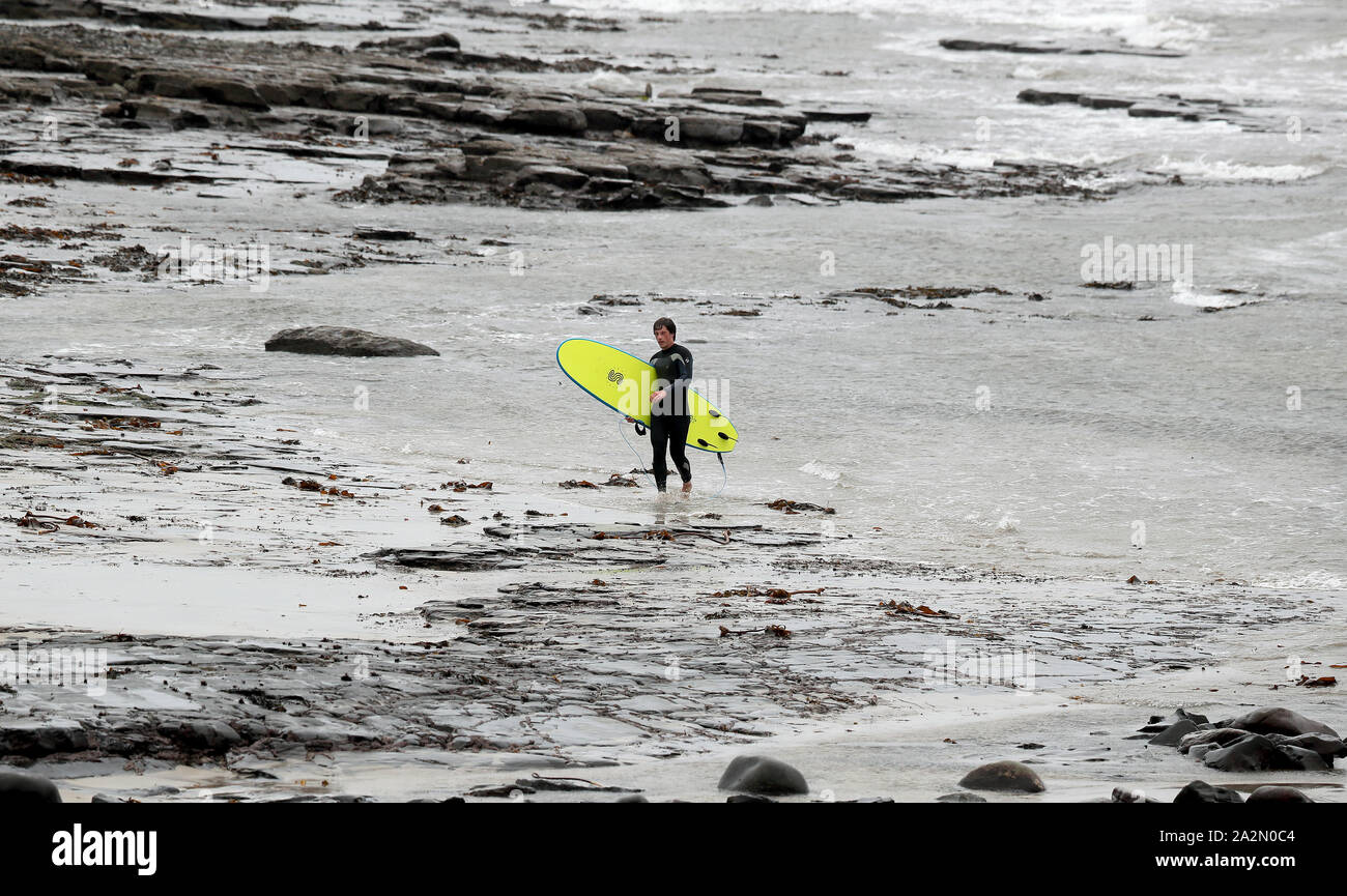 A surfer leaves the water in Lahinch, County Clare, on the West Coast of Ireland as storm Lorenzo is expected to make landfall, with a status orange wind warning and a yellow rain warning having been issued. Stock Photo