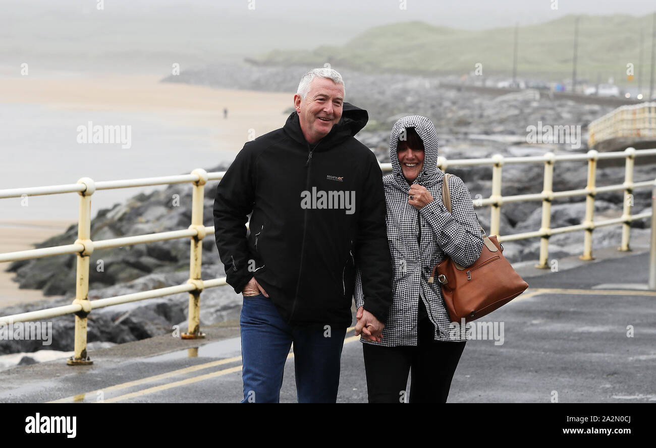 People walk along the sea front in Lahinch, County Clare, on the West Coast of Ireland as storm Lorenzo is expected to make landfall, with a status orange wind warning and a yellow rain warning having been issued. Stock Photo