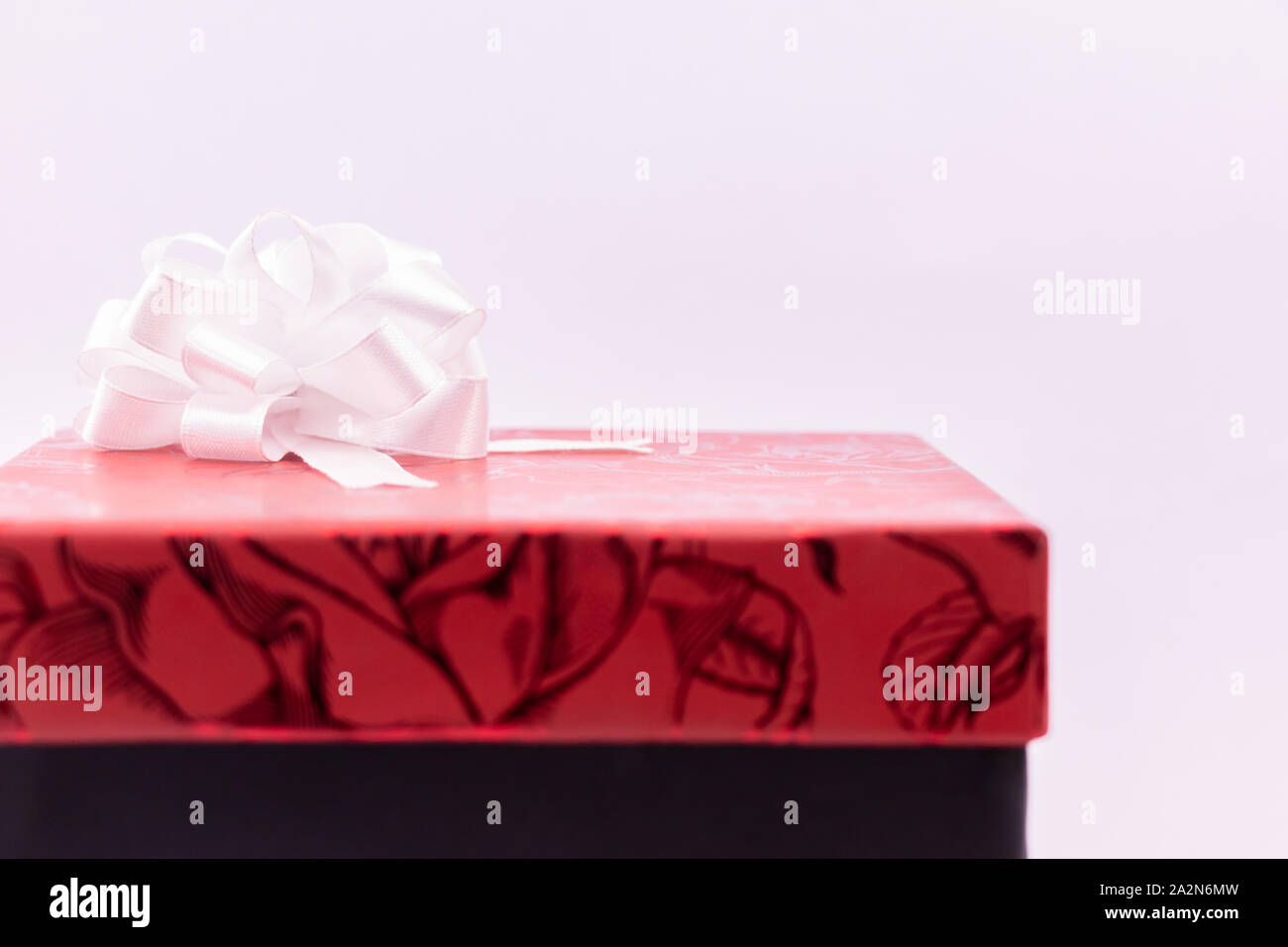 Red gift box decorated with ribbon on white background Stock Photo - Alamy
