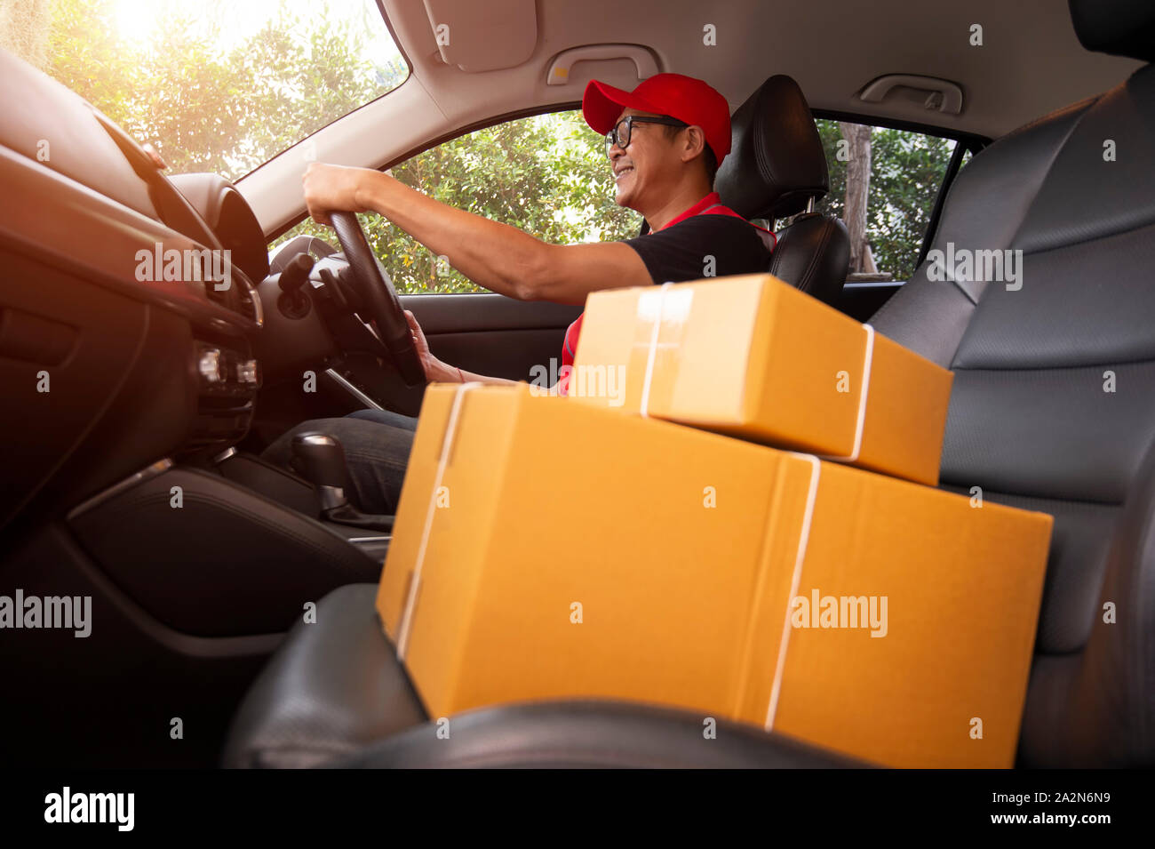The delivery driver Man driving van with parcels box on seat outside