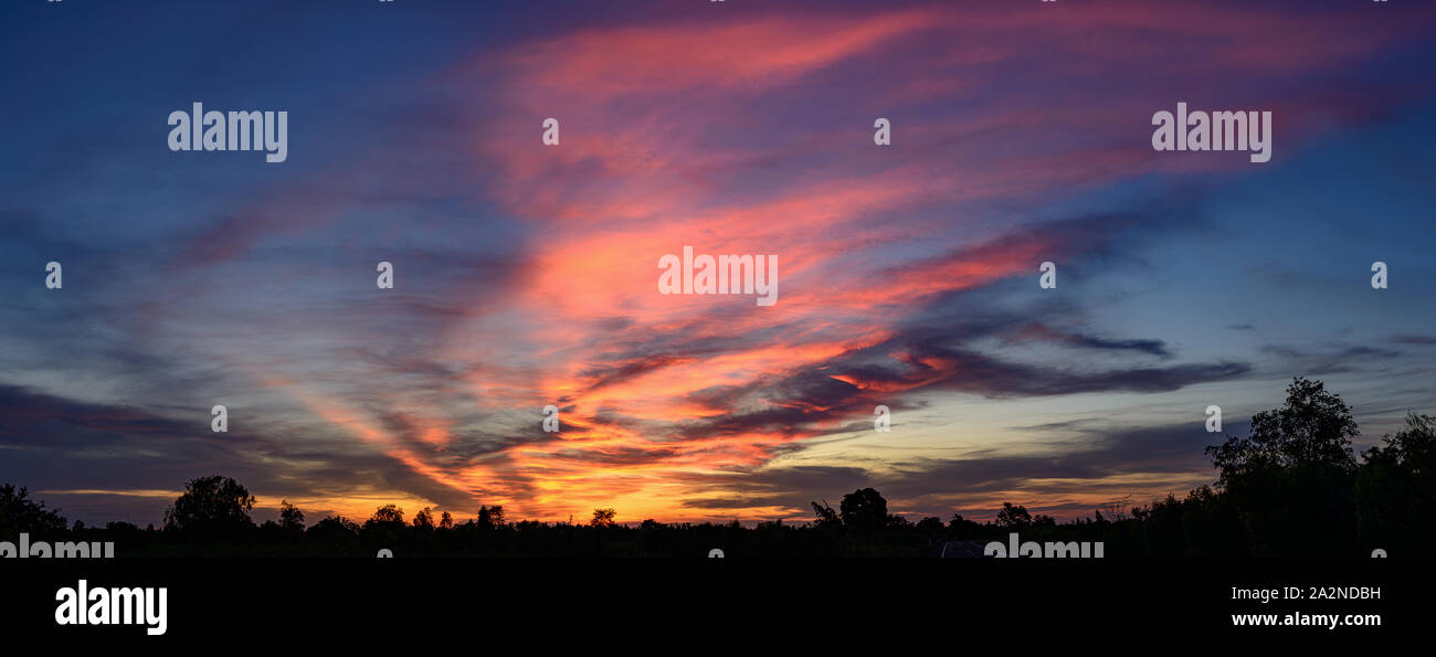 Wide panorama of sunset sky with clouds and sunlight over farm Stock ...