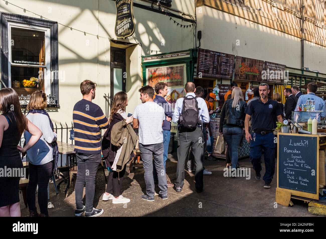 People queueing for takeaway at food stall, St Nicholas Market, Bristol, UK Stock Photo