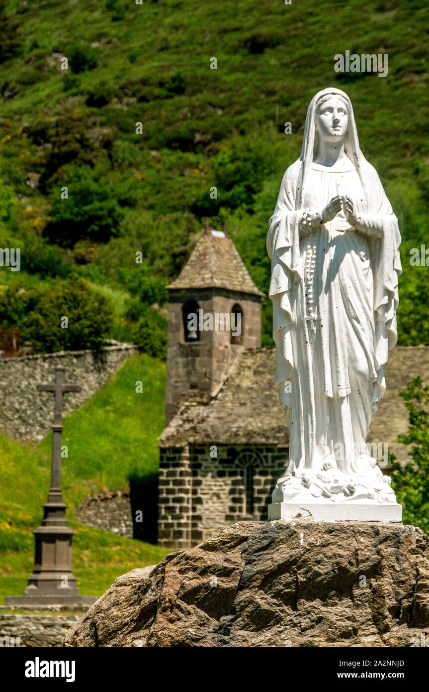 Statue in front of chapel near castle of Alleuze in Cantal, Auvergne, France Stock Photo