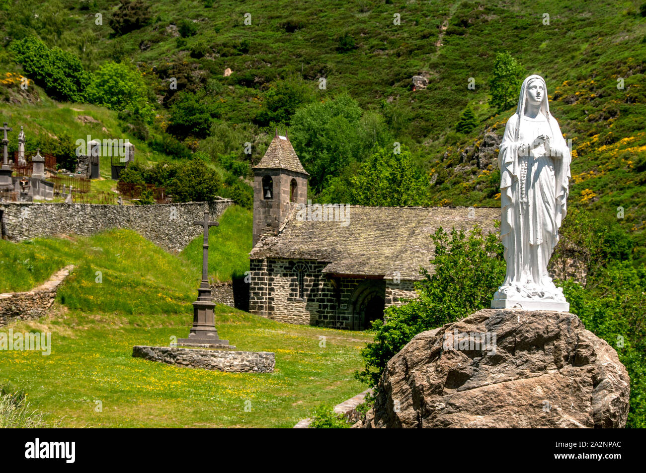 Statue in front of chapel near castle of Alleuze in Cantal, Auvergne, France Stock Photo