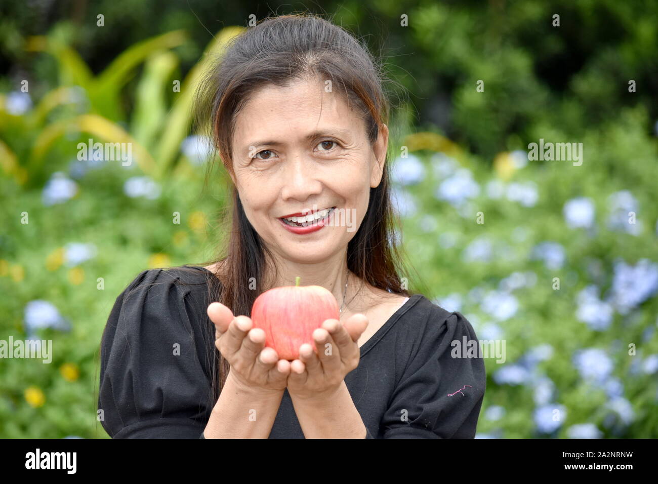 Happy Female Senior With An Apple Stock Photo