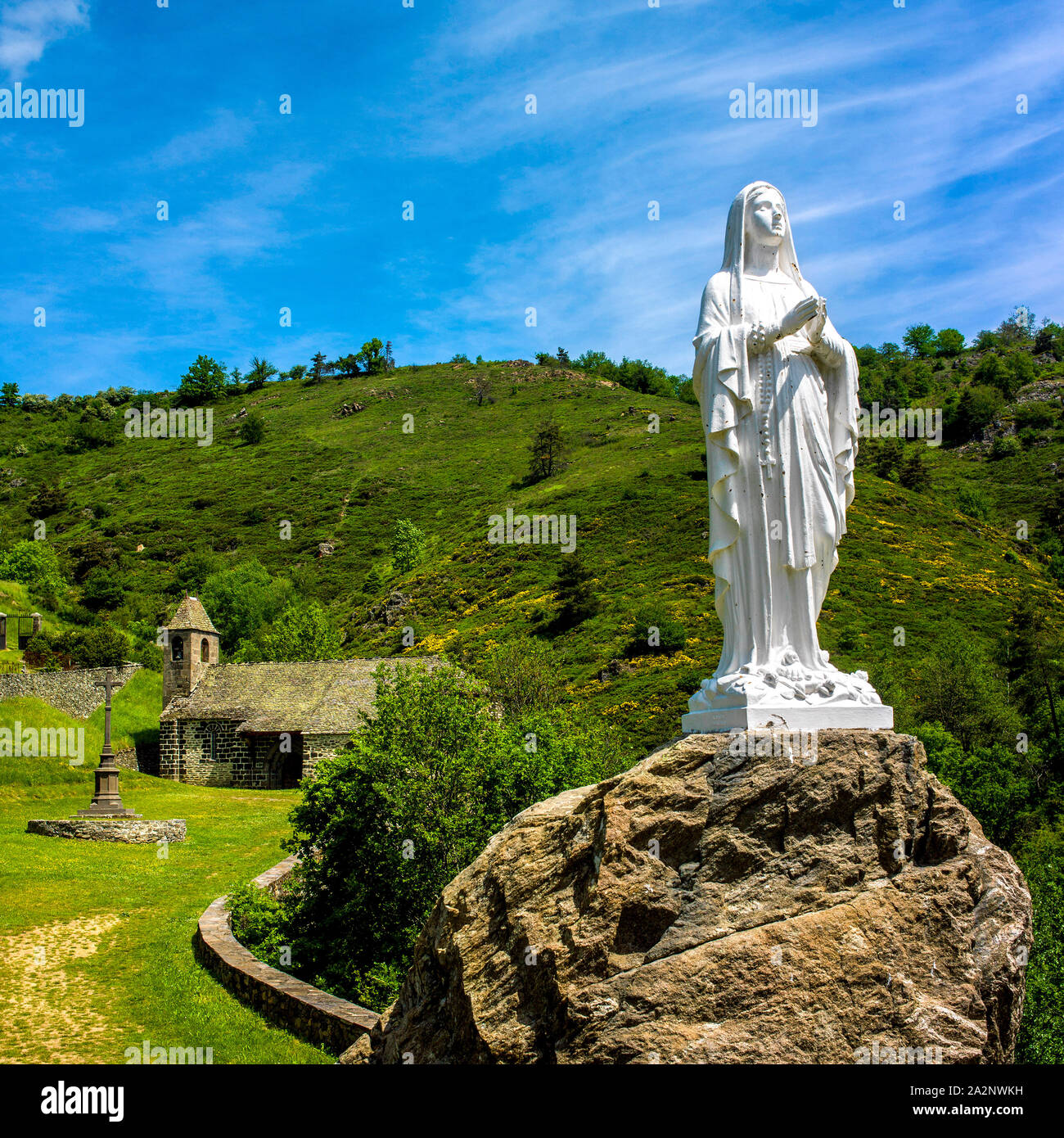 Statue in front of chapel near castle of Alleuze in Cantal, Auvergne, France Stock Photo