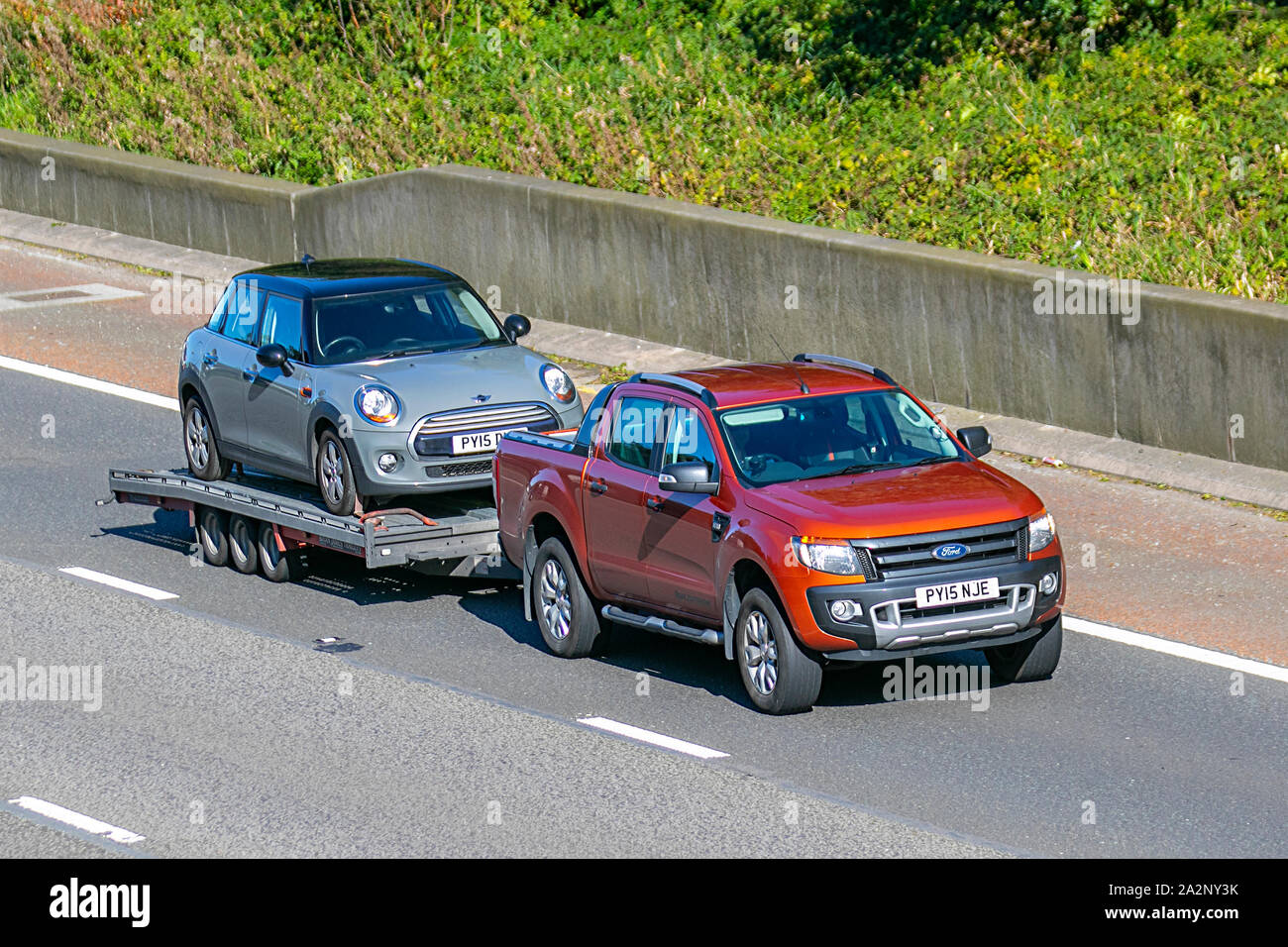 2015 Red Ford Ranger Wildtrak 4x4 Tdci Driving On The M6 Towing Car On Trailer In Lancaster Uk Stock Photo Alamy