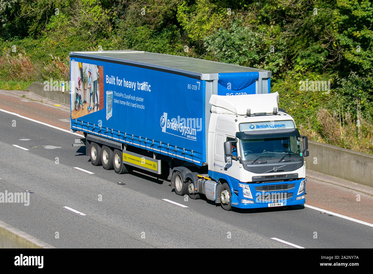 British Gypsum- Saint Gobain; heavy bulk Haulage delivery trucks, haulage, lorry, transportation, truck, cargo, Volvo vehicle, delivery, transport industry, supply chain freight on the M6 at Lancaster, UK Stock Photo