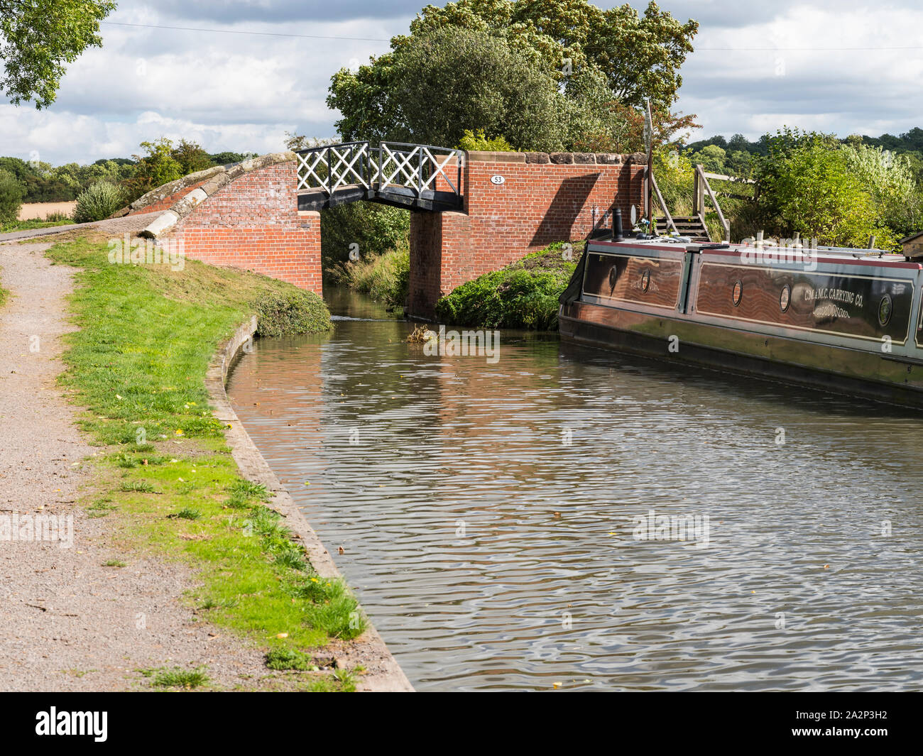 An old lift bridge at the canal basin on the Stratford on Avon canal with a leisure boat moored. Stock Photo