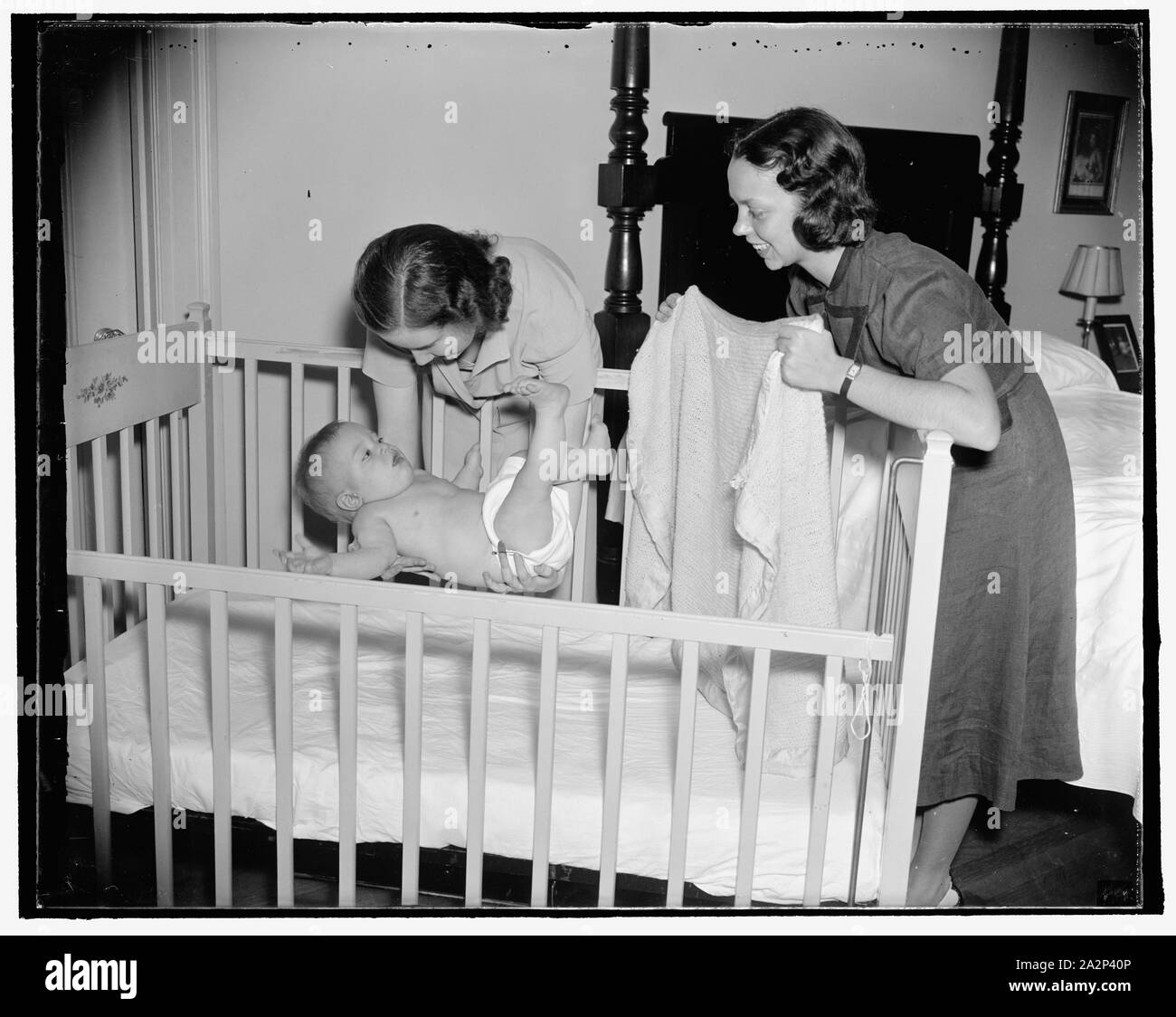 Putting baby in crib Stock Photo Alamy