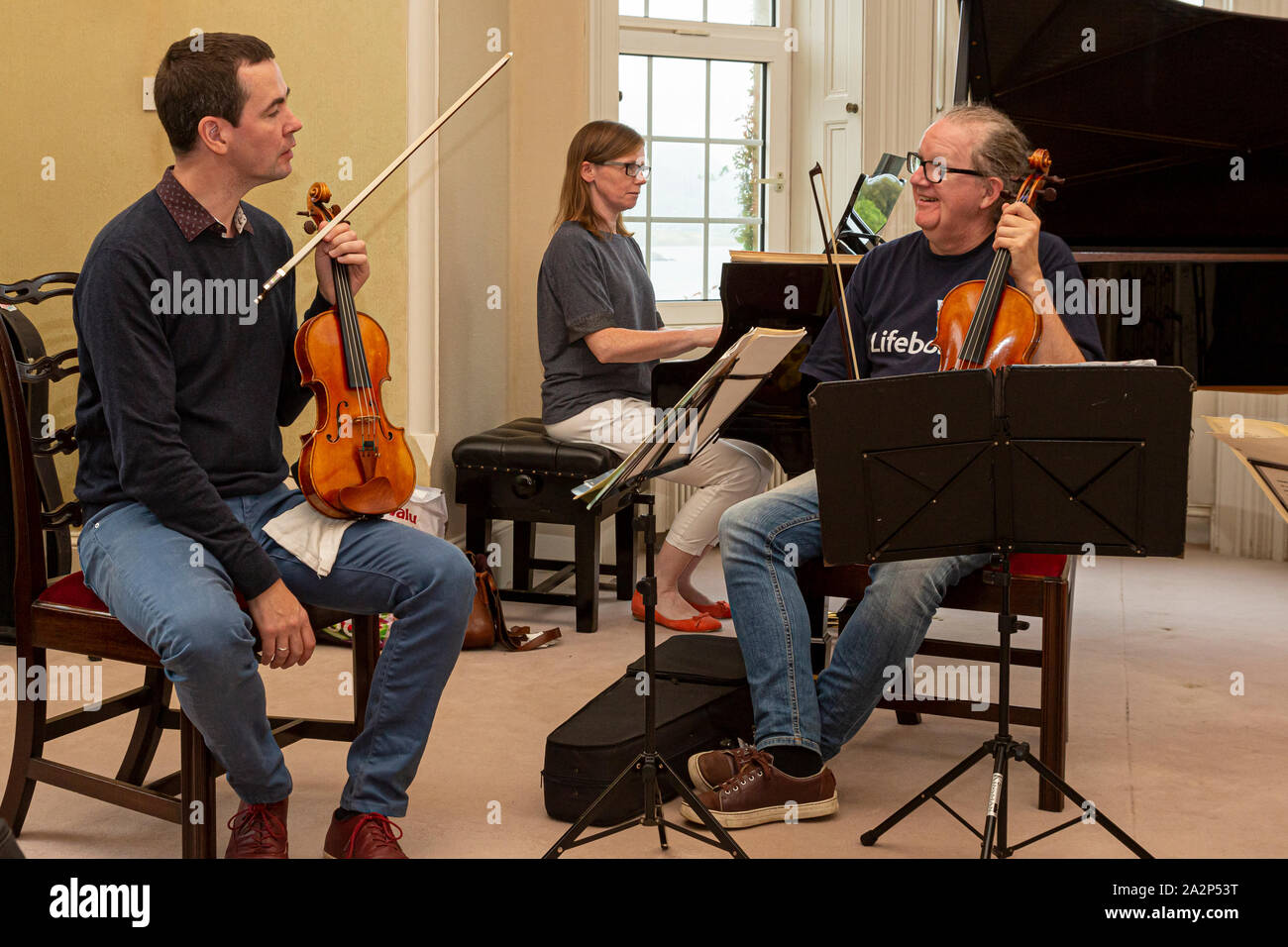 Musicians enjoying a joke while they rehearse Stock Photo