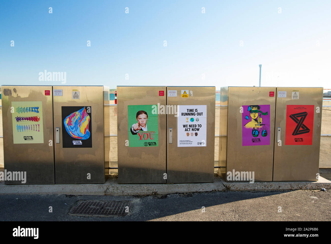 Extinction Rebellion posters, or flyers, that have been placed on power boxes on Weymouth seafront which include one with an image of Swedish climate Stock Photo