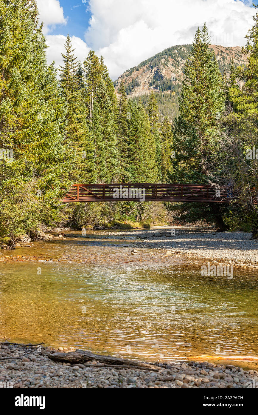 Small bridge over running stream in the Colorado mountains Stock Photo