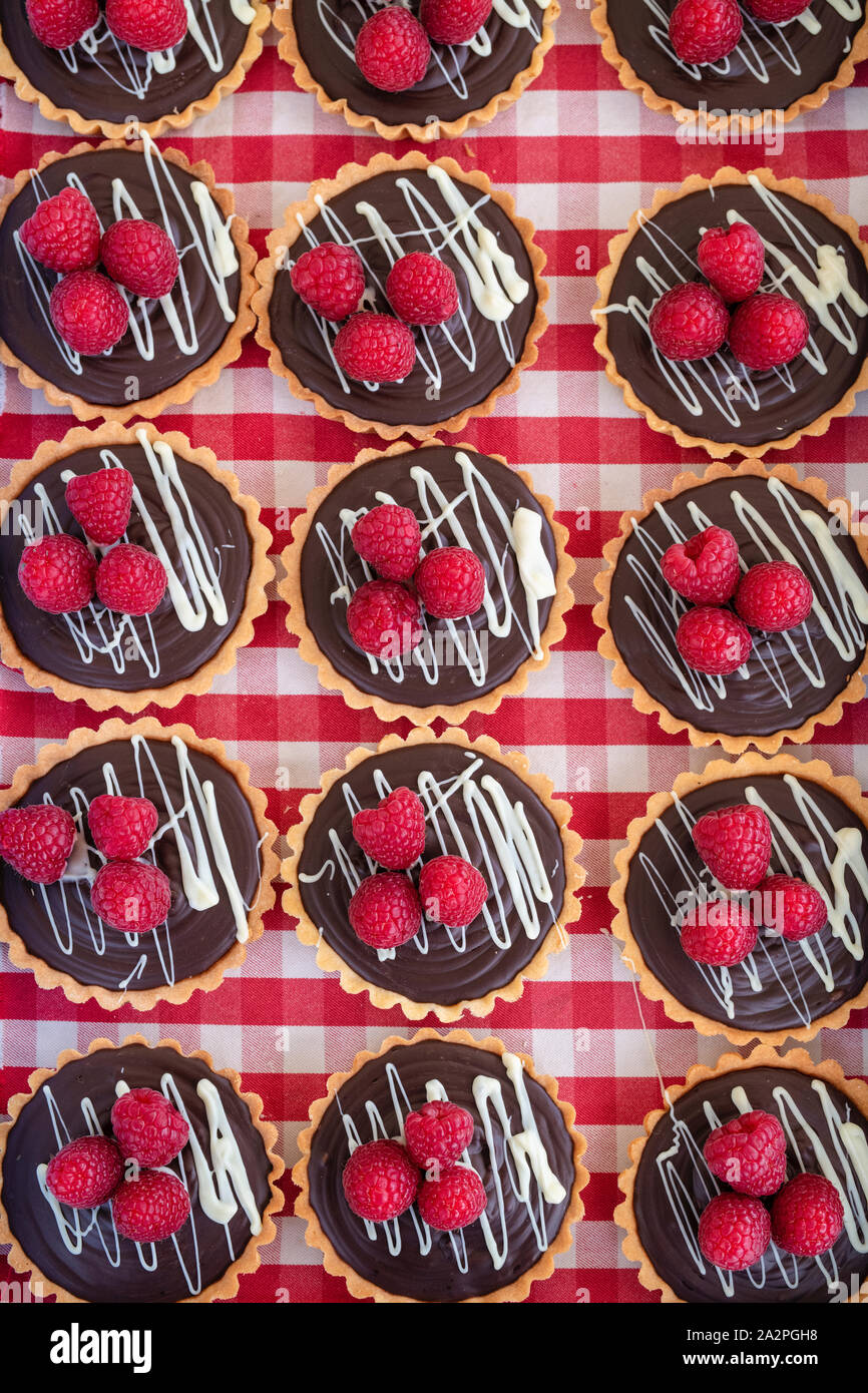 Chocolate and raspberry tarts on a gingham background Stock Photo