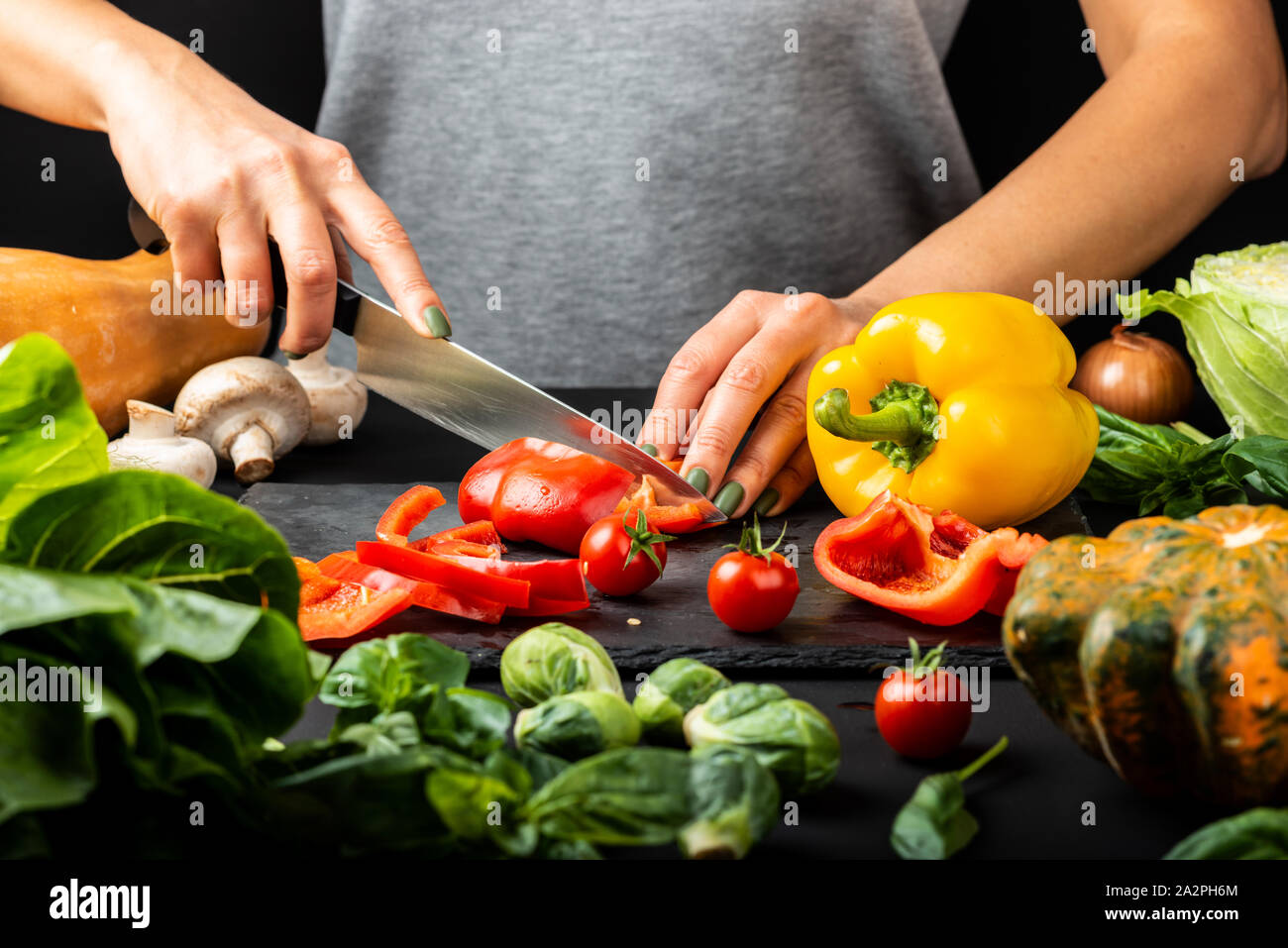 Woman's hands prepare vegetarian food, cut different vegetables