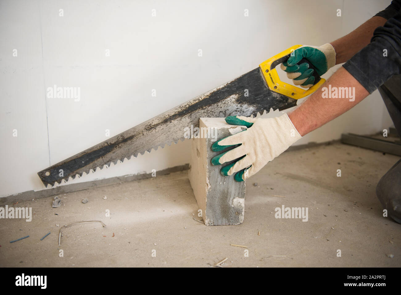 a man works with handsaw at the repair of a flat Stock Photo