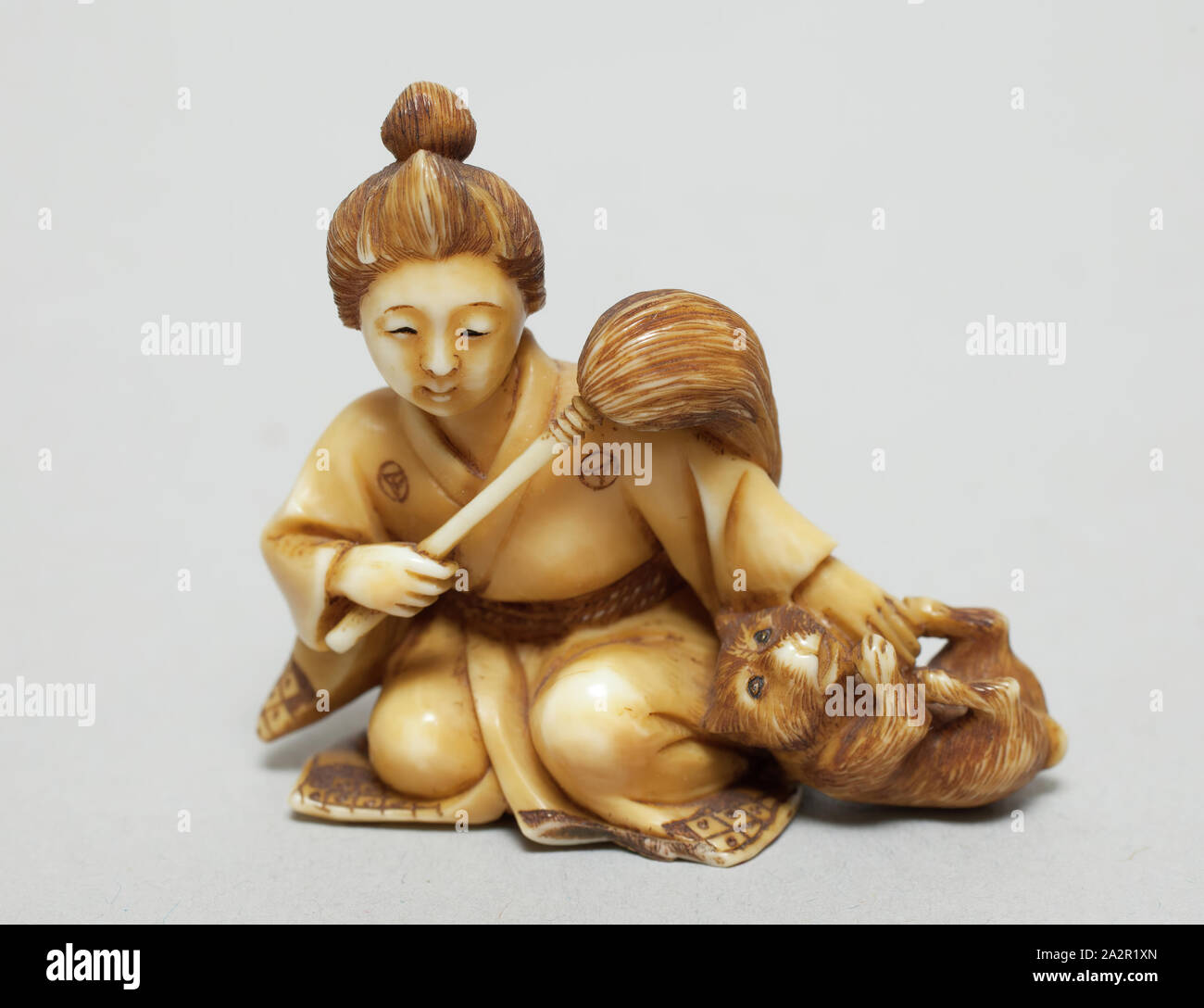 Unknown (Japanese), Seated Giesha with Puppy, 1716/1868, height: 1 3/8 in Stock Photo
