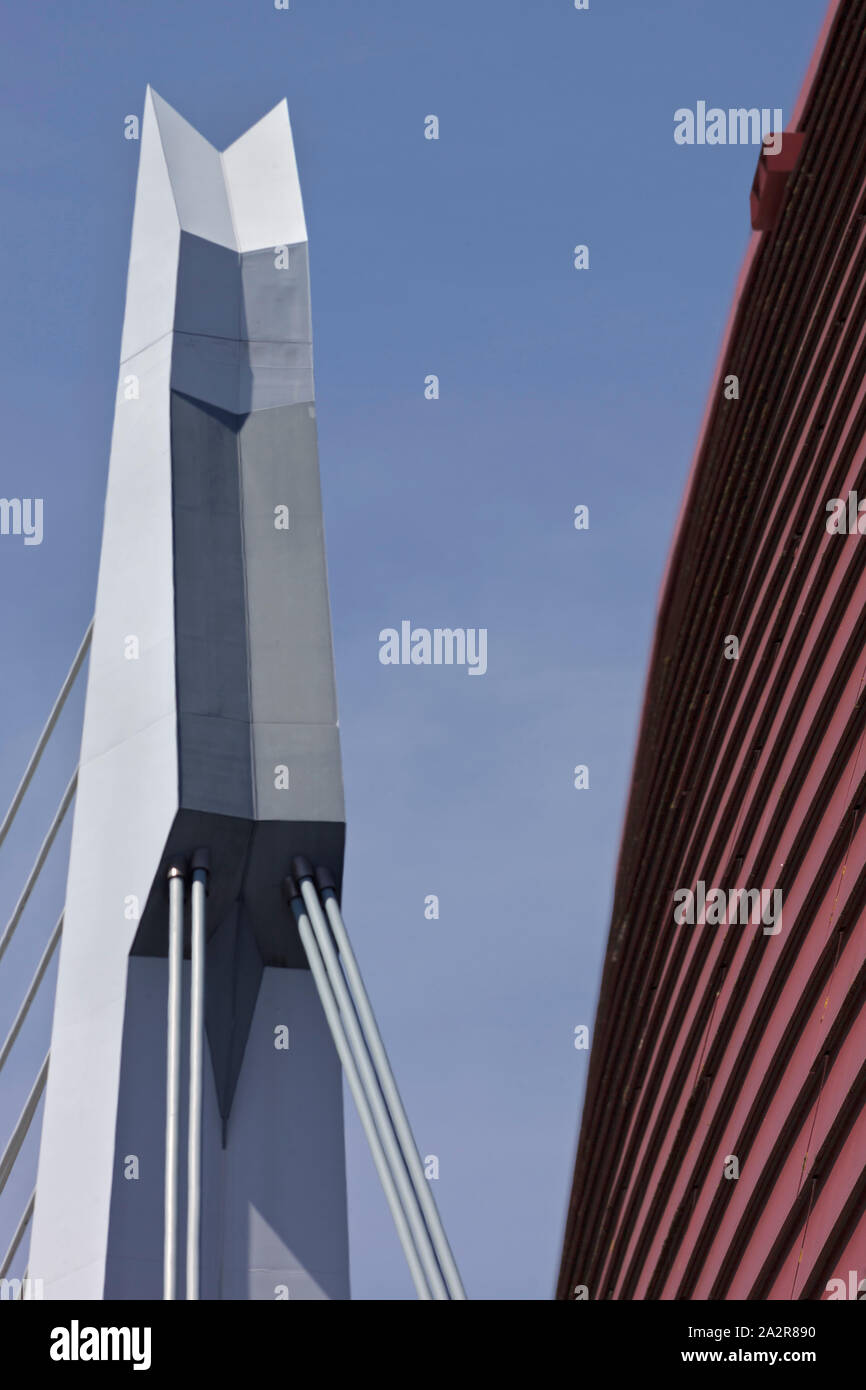 Detail of red curved exterior cladding with Erasmus Bridge in background, against clear sky. Nieuwe Luxor Theater (New Luxor Theatre), Rotterdam, Neth Stock Photo