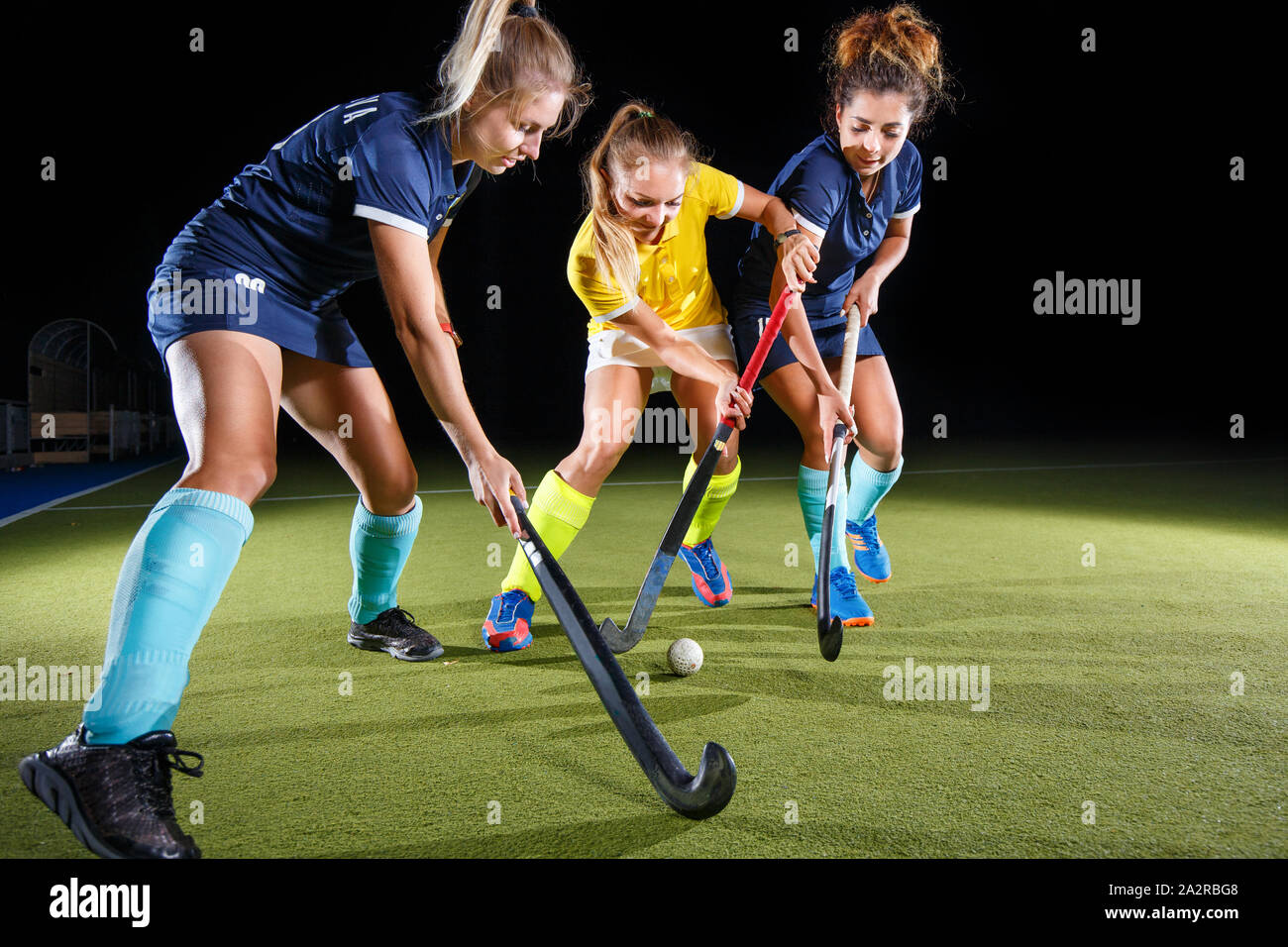 Field hockey female players struggle for the ball. Concept image hockey team game Stock Photo
