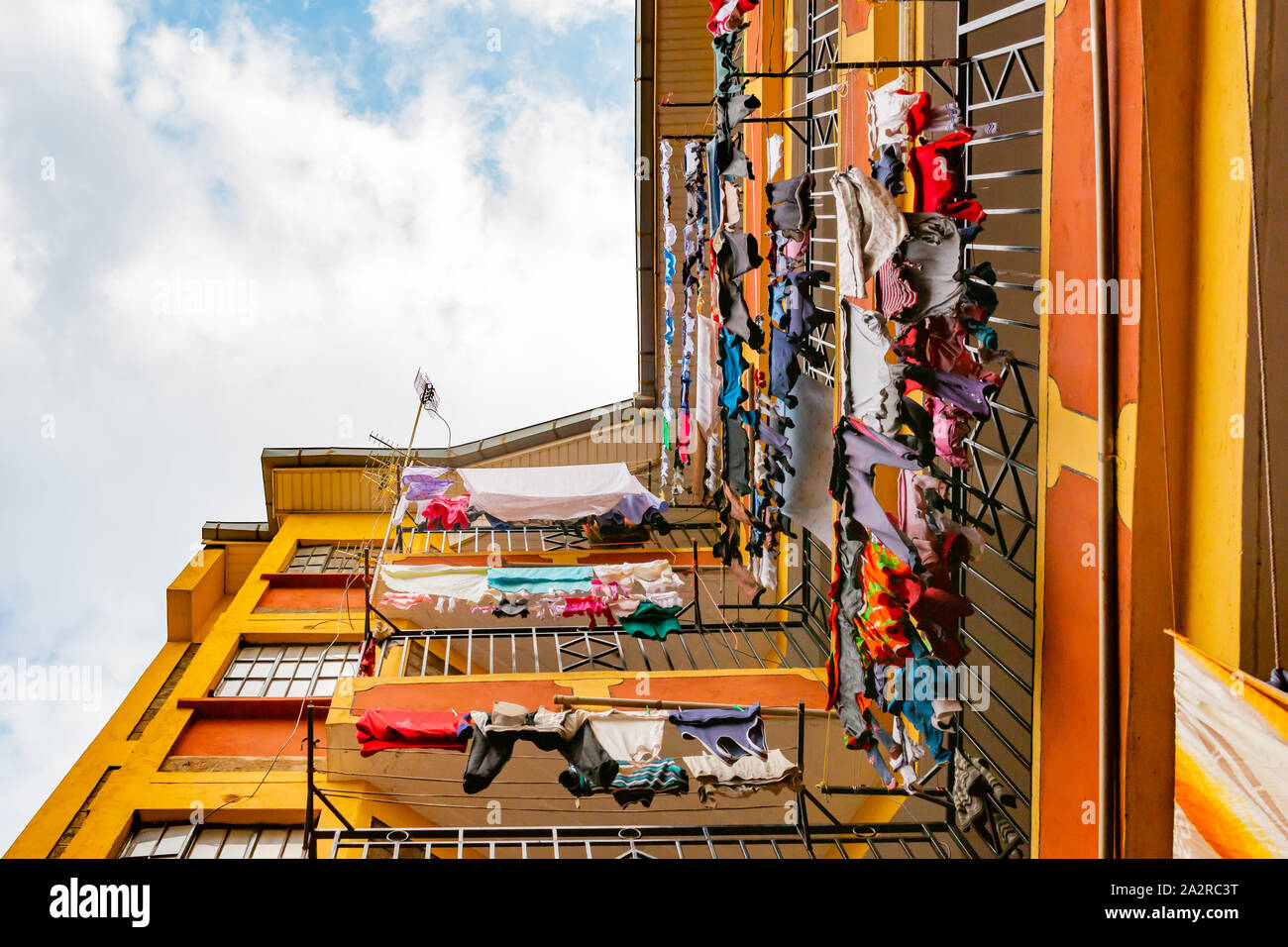 Nairobi, Kenya – June 20th, 2019: Colour photograph looking directly up inside a residential tower block with colourful laundry hanging from balconies Stock Photo