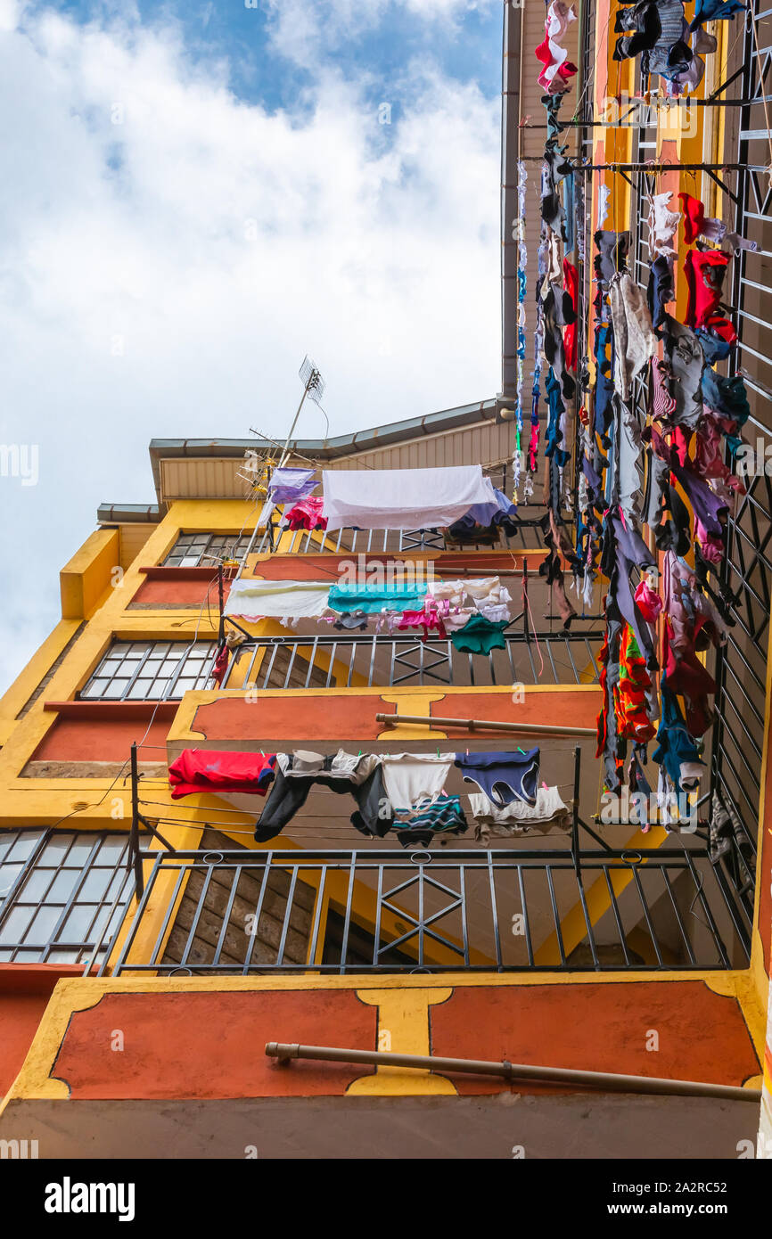 Nairobi, Kenya – June 20th, 2019: Colour photograph looking directly up inside a residential tower block with colourful laundry hanging from balconies Stock Photo