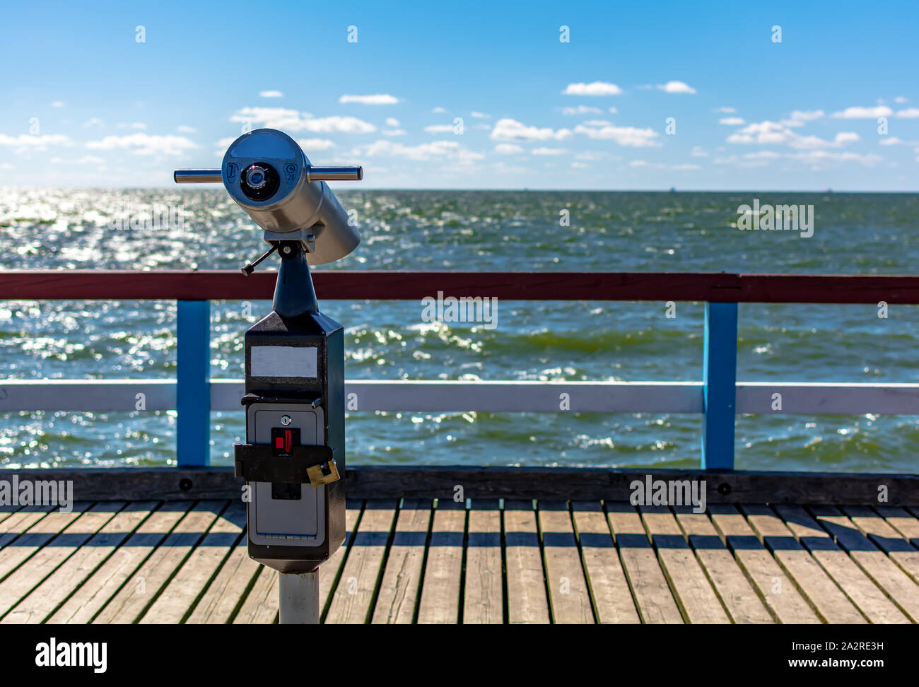 Close-Up of sightseeing binoculars with sea background. Coin operated spyglass or telescope looking over Baltic sea at Palanga sea pier, Lithuania. Stock Photo