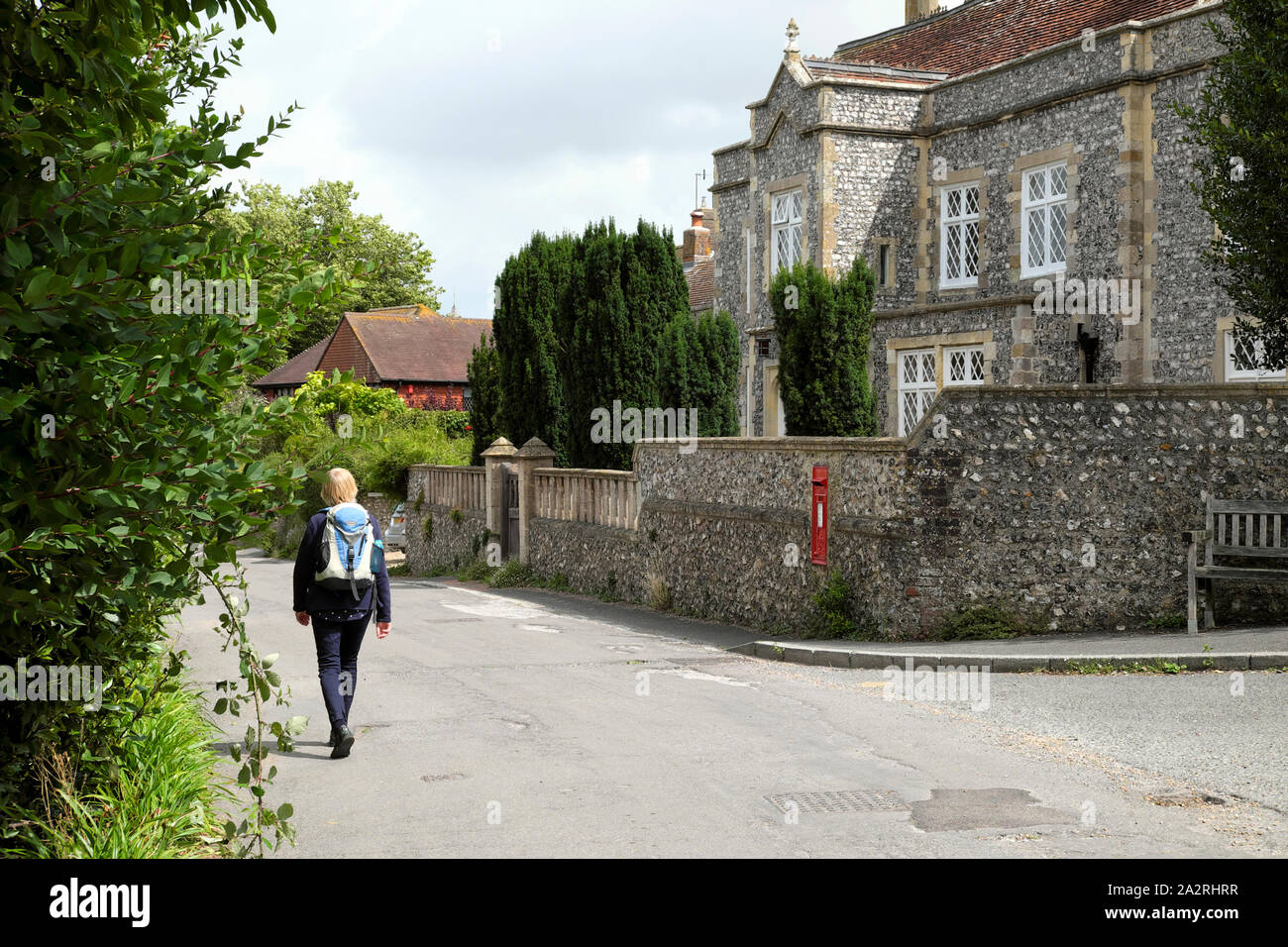 Rear view of a woman walker walking to Virginia Woolf home Monks House through the village of Rodmell East Sussex England UK  KATHY DEWITT Stock Photo