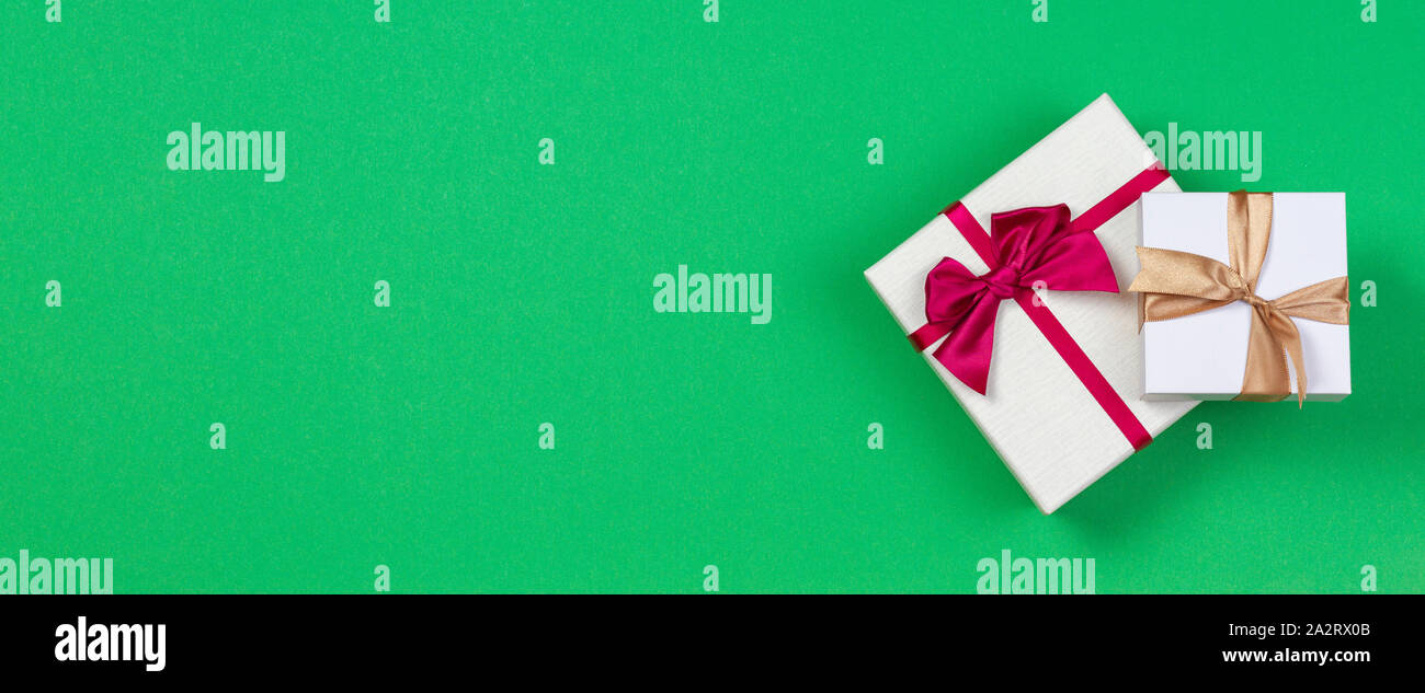 Two gift present boxes with ribbon on green background, top view Stock Photo