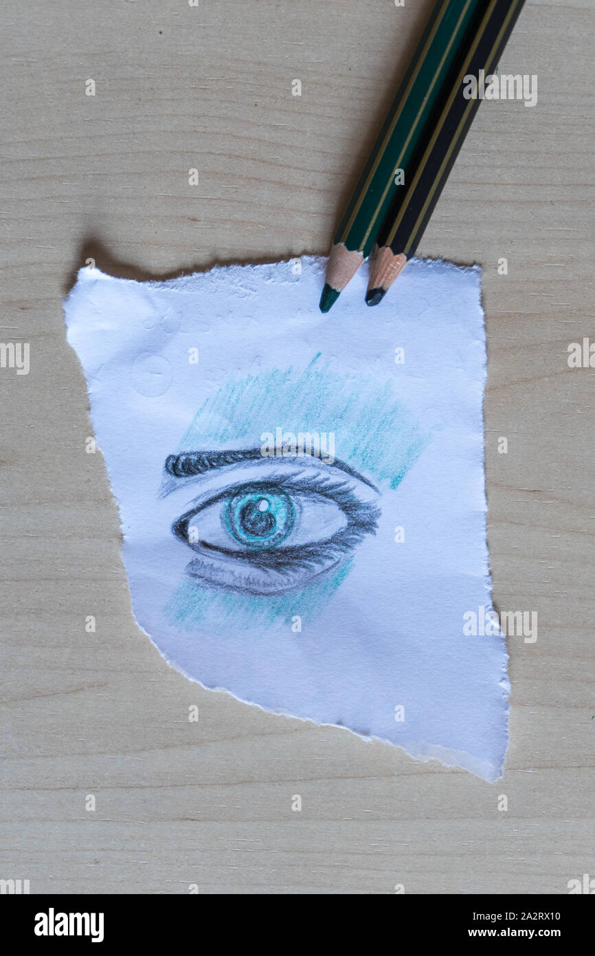 Eye drawn on a sheet of paper with colored pencils. Stock Photo