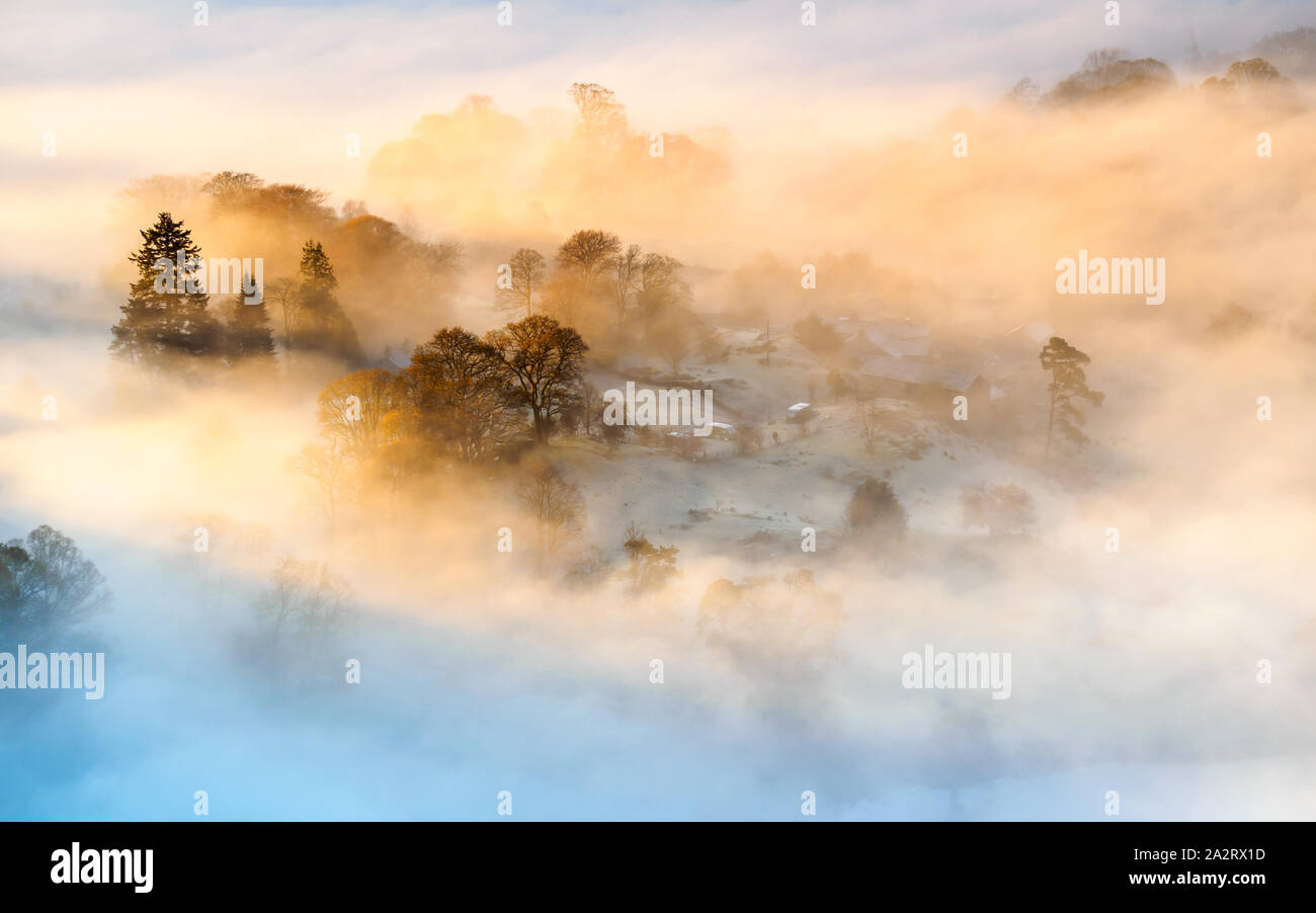 A temperature inversion engulfs the frosty landscape on a beautiful autumn morning overlooking Loughrigg Fold in the English Lake District. Stock Photo