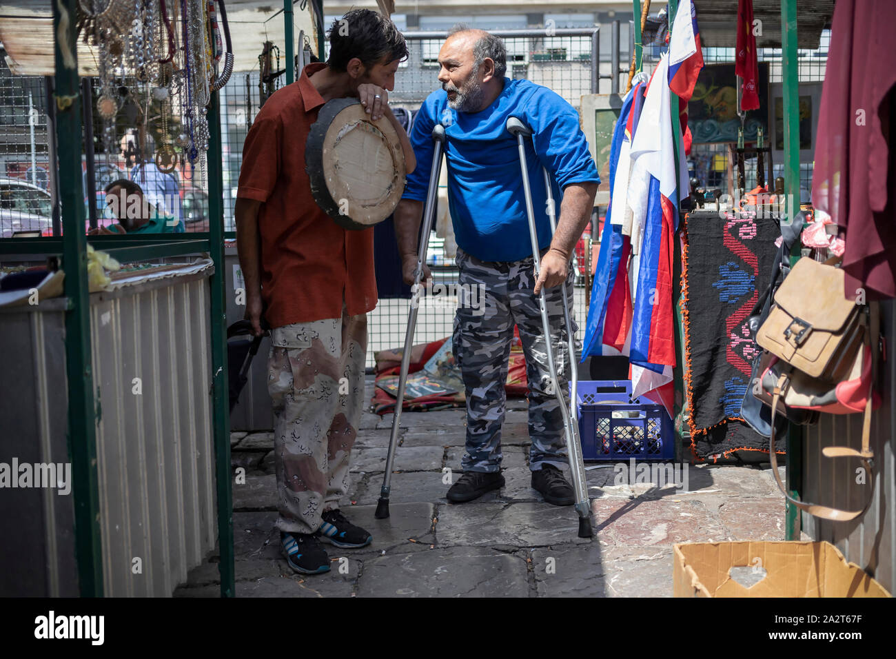 Belgrade, Serbia, Aug 15, 2019: Two gypsy men standing and having a conversation at a flea market section of Kalenić Green Market Stock Photo