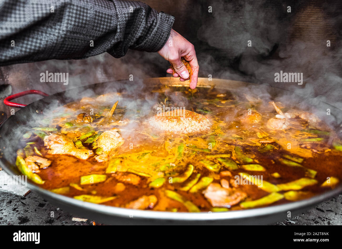 Cooking and making a traditional Spanish Paella over open fire