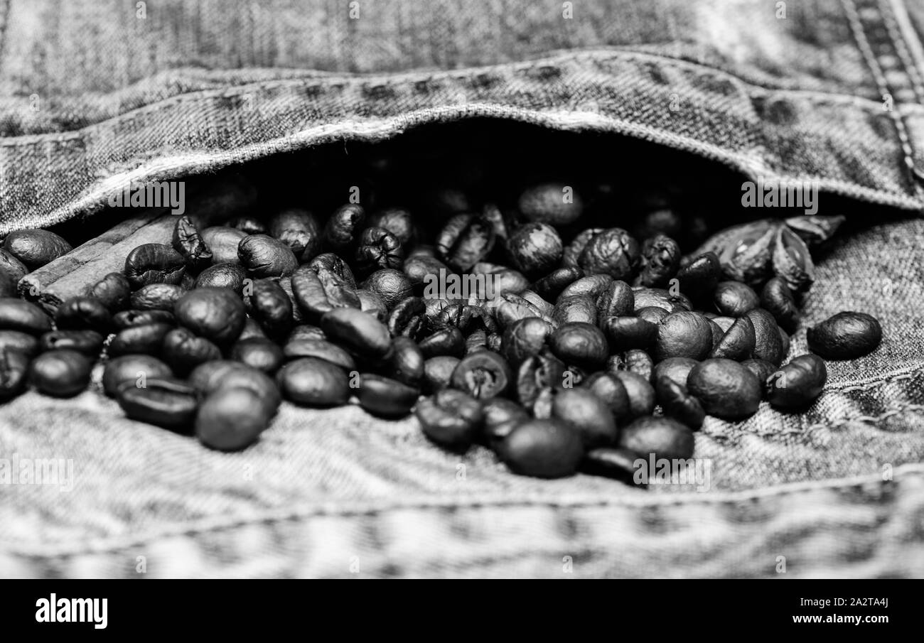 Fresh roasted coffee close up. Beans and spices in jeans pocket. Coffee