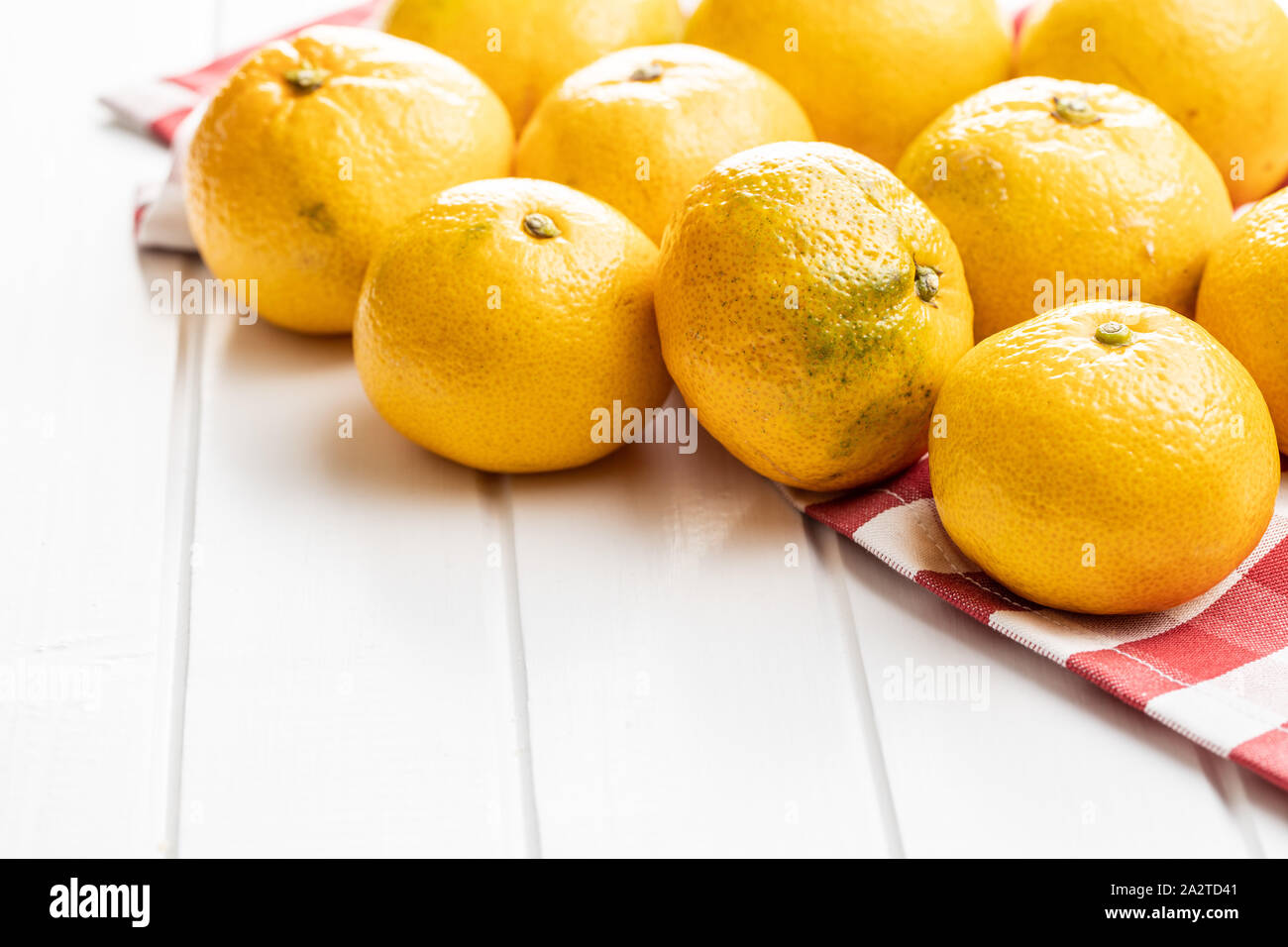 Fresh yellow tangerines on checkered napkin. Stock Photo