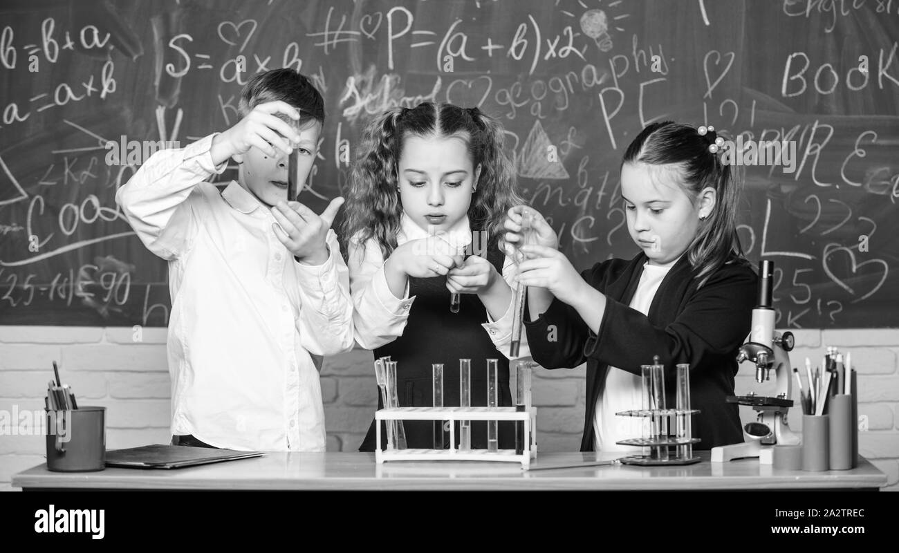 Happy children. Biology lesson. Little kids learning chemistry in lab. biology education. students doing biology experiments with microscope in lab. Biology equipment. The formula is almost complete. Stock Photo