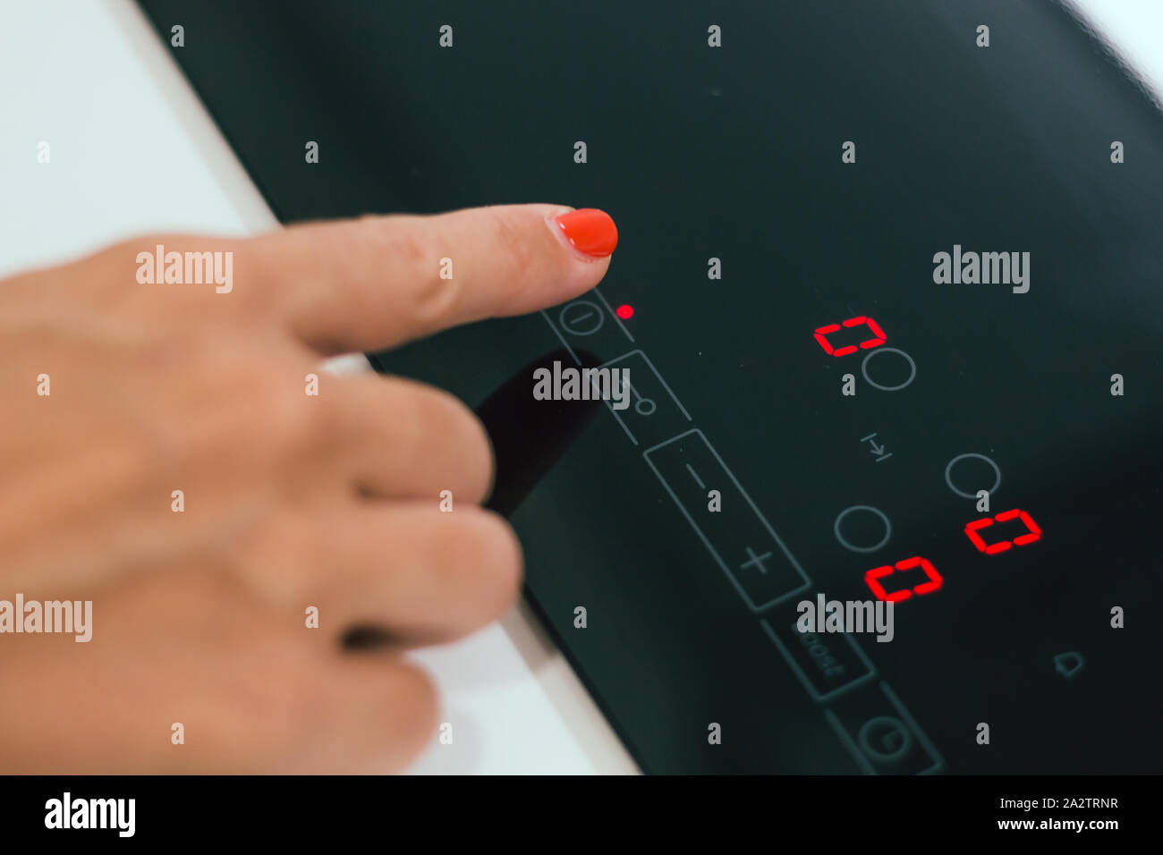 Closeup female hand turning on electric hob Stock Photo Alamy