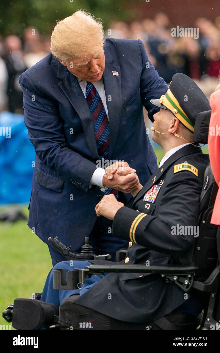 U.S President Donald Trump greets wounded warrior Army Captain Luis Avila during a ceremony marking the retirement of outgoing Chairman of the Joint Chiefs Gen. Joseph Dunford and the elevation of incoming Chairman Gen. Mark Milley, left, at Summerall Field, Joint Base Myer-Henderson Hall September 30, 2019 in Arlington, Virginia. Stock Photo
