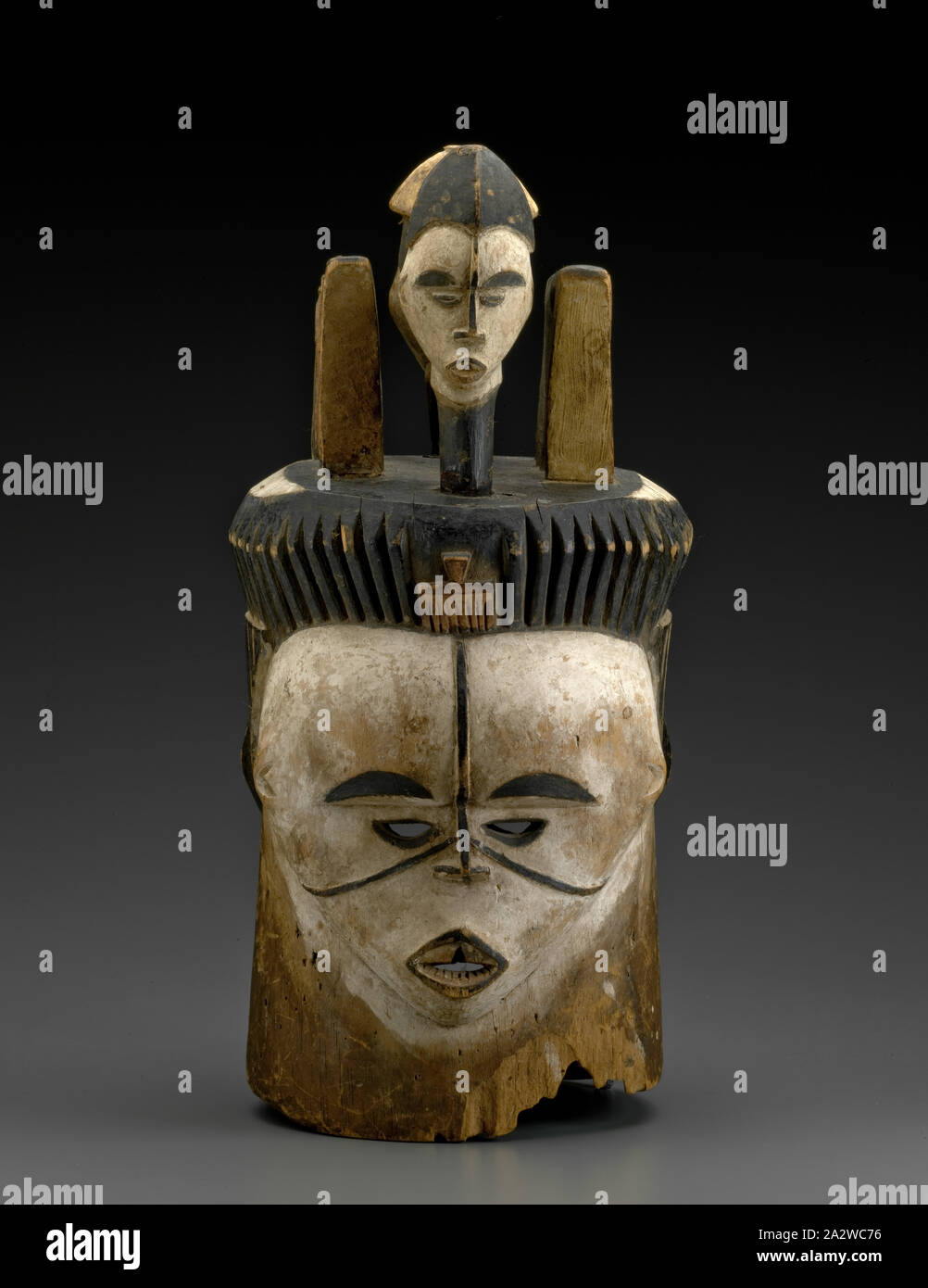 Janusfaced helmet mask with two human head finials, pigment, H 19 in