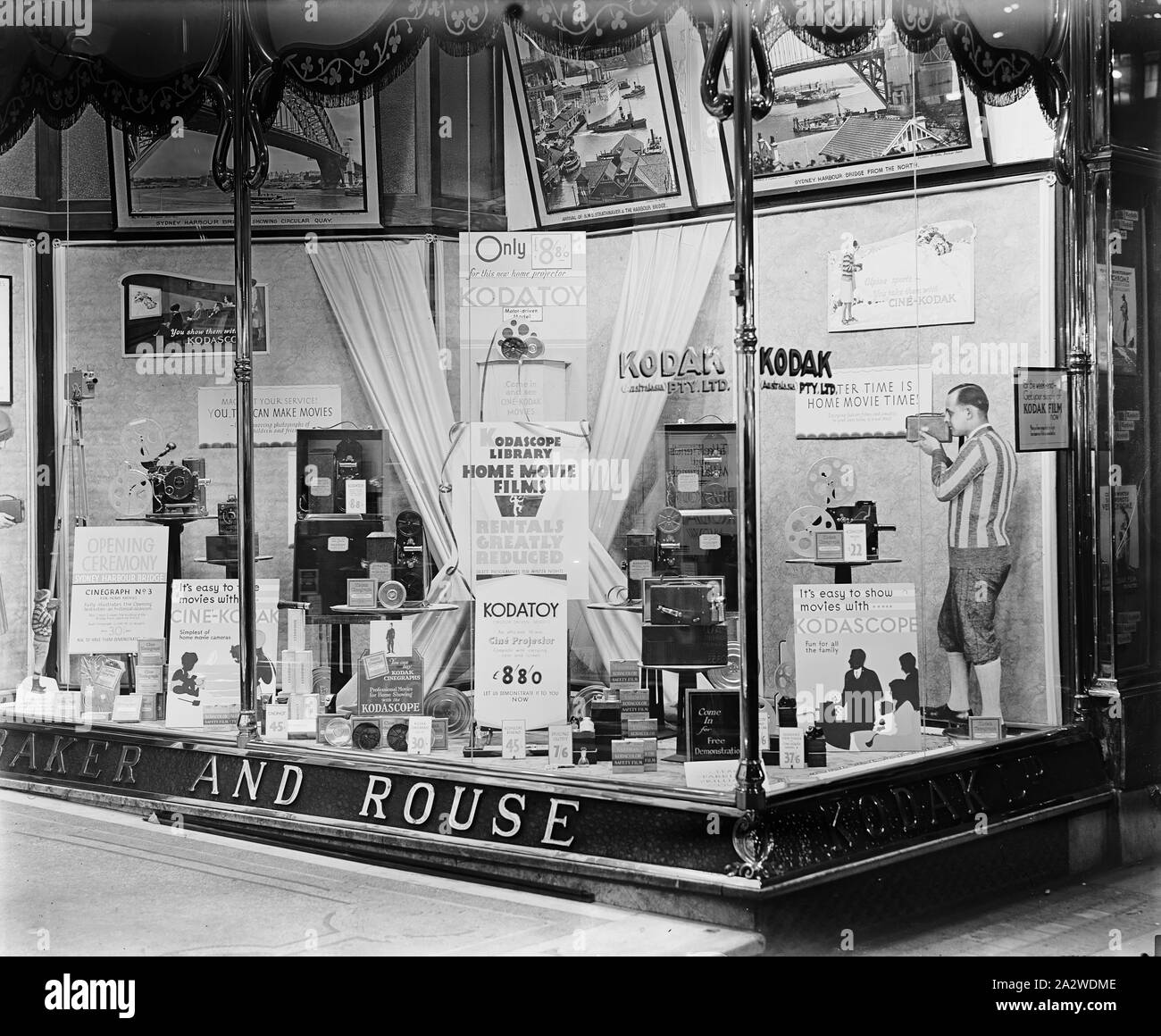 Glass Negative, Shopfront Display, Kodak Projectors, George St, Sydney, circa 1932, Black and white plate glass negative of the shopfront display at Sydney's Kodak branch at 379-381 George Street, circa 1932. As well as a small exhibition of Sydney Harbour Bridge opening photographs, there is a promotion for Kodak projectors, specifically the Kodatoy and Kodascope. The central display promotes the Kodascope library of home movie rentals and the Kodatoy home movie projector Stock Photo