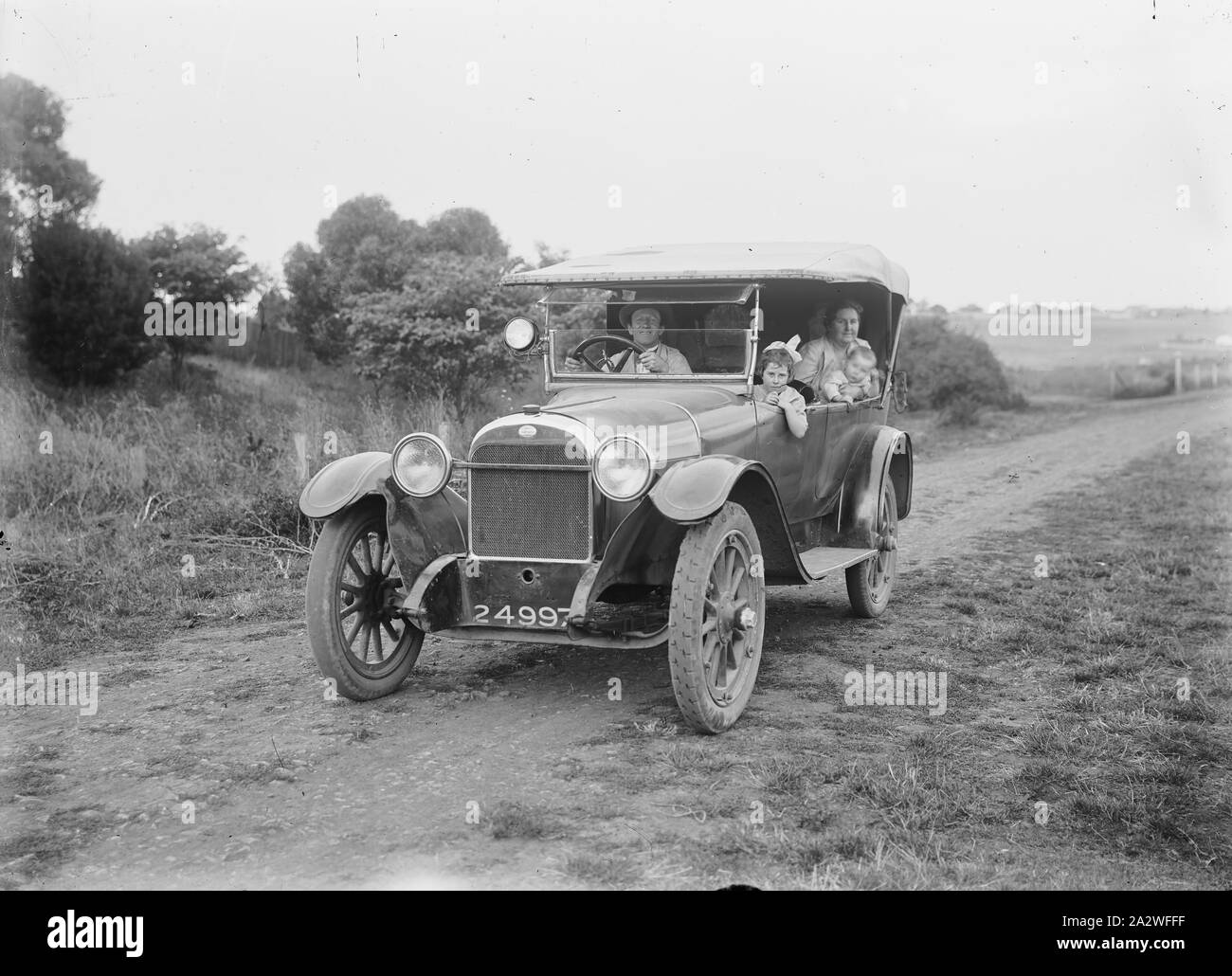 Glass Negative - Family in Car on Country Road, circa 1930s, A black and white, half plate negative featuring a photograph of a family in a motor car on a country road by the sea, circa 1930s Stock Photo