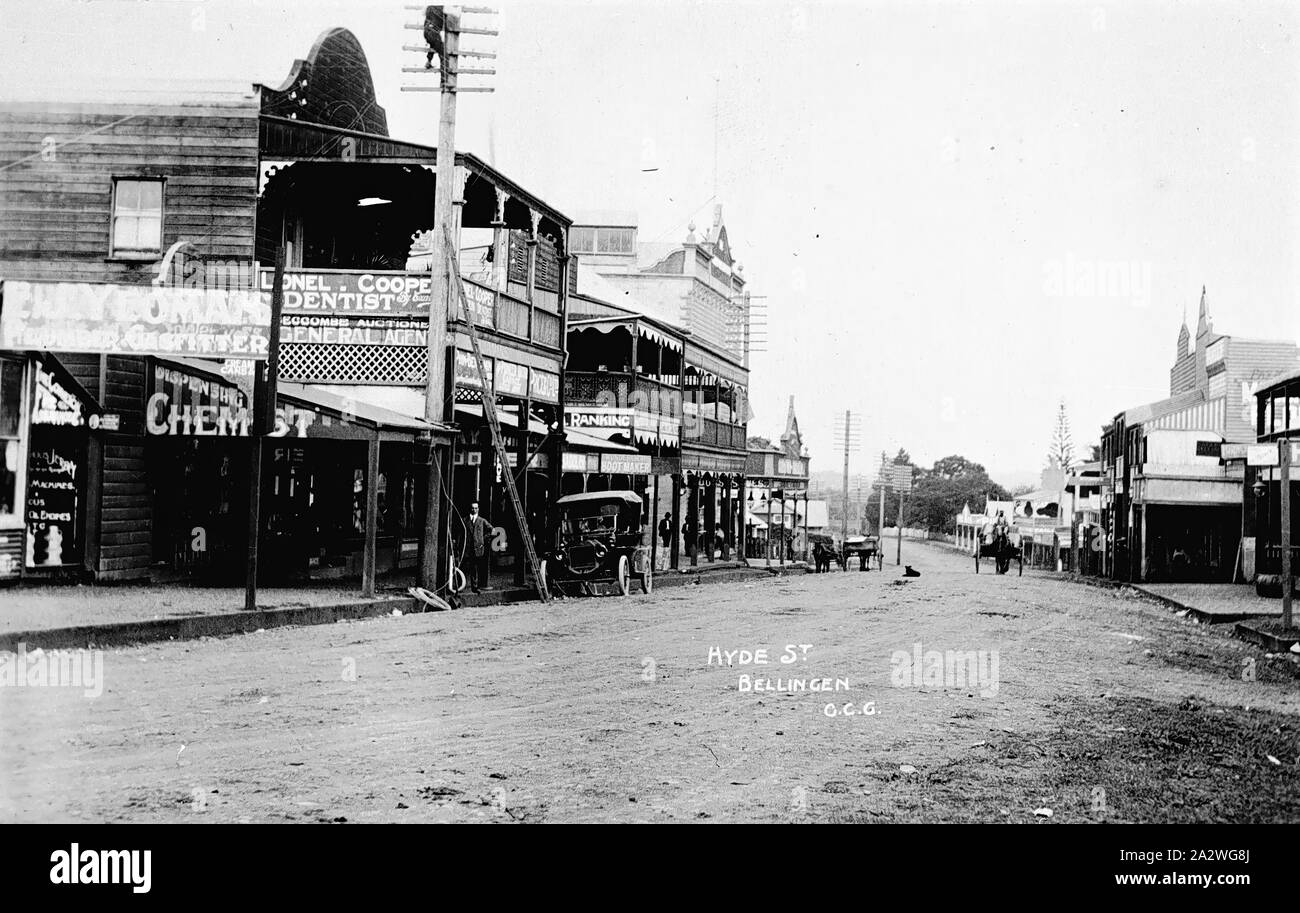 Negative - Bellingen, New South Wales, Dec 1916, Horse-drawn vehicles and cars in the main street of Bellingen. Shops include a chemist and Lionel Cooper, dentist Stock Photo
