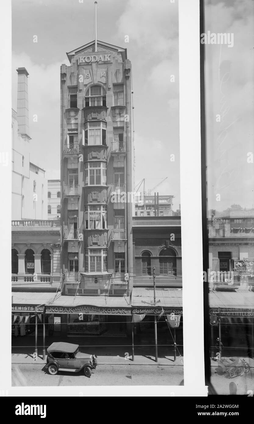 Glass Negative, Building Exterior, Queen Street, Brisbane, circa 1930s, Black and white full plate glass negative of the Kodak Australasia Pty Ltd building on Queen Street St, Brisbane, Queensland, circa 1930s. This oblique street view shows neighbouring high rises, a car parked on the street. To the far right, beyond the area that a mask has been applied to delineate an area for developing, a man with crutches and a top hat can be seen leaning against an awning pole Stock Photo
