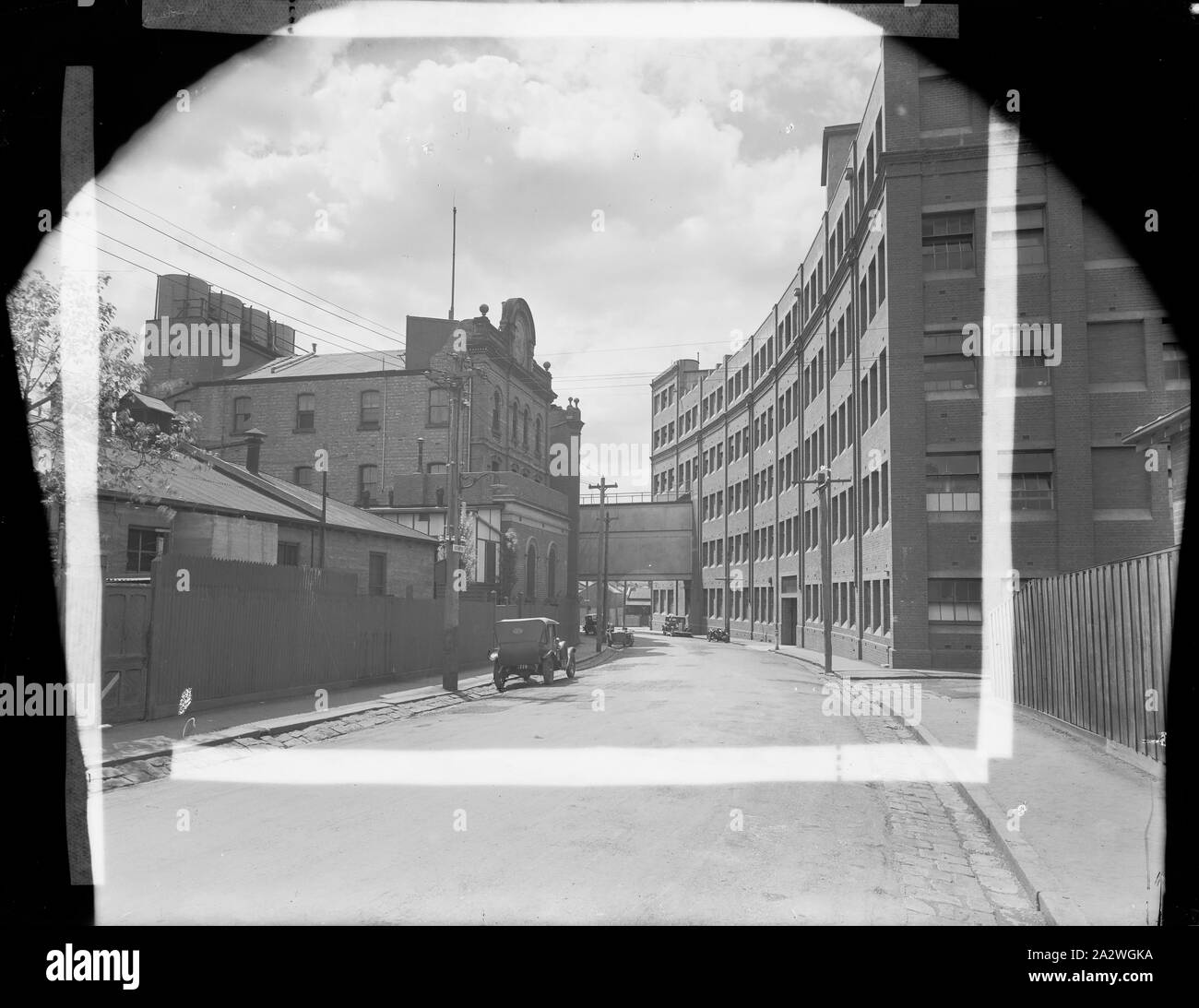 Glass Negative, Kodak Factory Along Southampton Cres, Abbotsford, Victoria, circa 1930s, Black and white glass plate negative of the view along Southampton Crescent, Abbotsford, showing the exterior of the Kodak Australasia factory buildings in the 1930s. There is perforated white tape applied to the non-emulsion side of the image as a mask, indicating the position of a print. Yarra Grange was originally the home of Thomas Baker. In 1884 he established the Austral Plate Company on Stock Photo