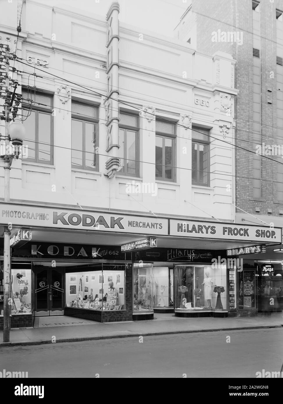 Negative, Shop Exterior, Perth, Western Australia, circa 1940s, Black and white film negative of the Kodak Australasia Pty Ltd branch store at 662 Hay Street, Perth, Western Australia, taken in the 1940s. This street view shows the Kodak shop front displays of photographs and photographic products, and the windows of neighbouring Hilary's Frock shop. collection of products, promotional materials, photographs and working life Stock Photo