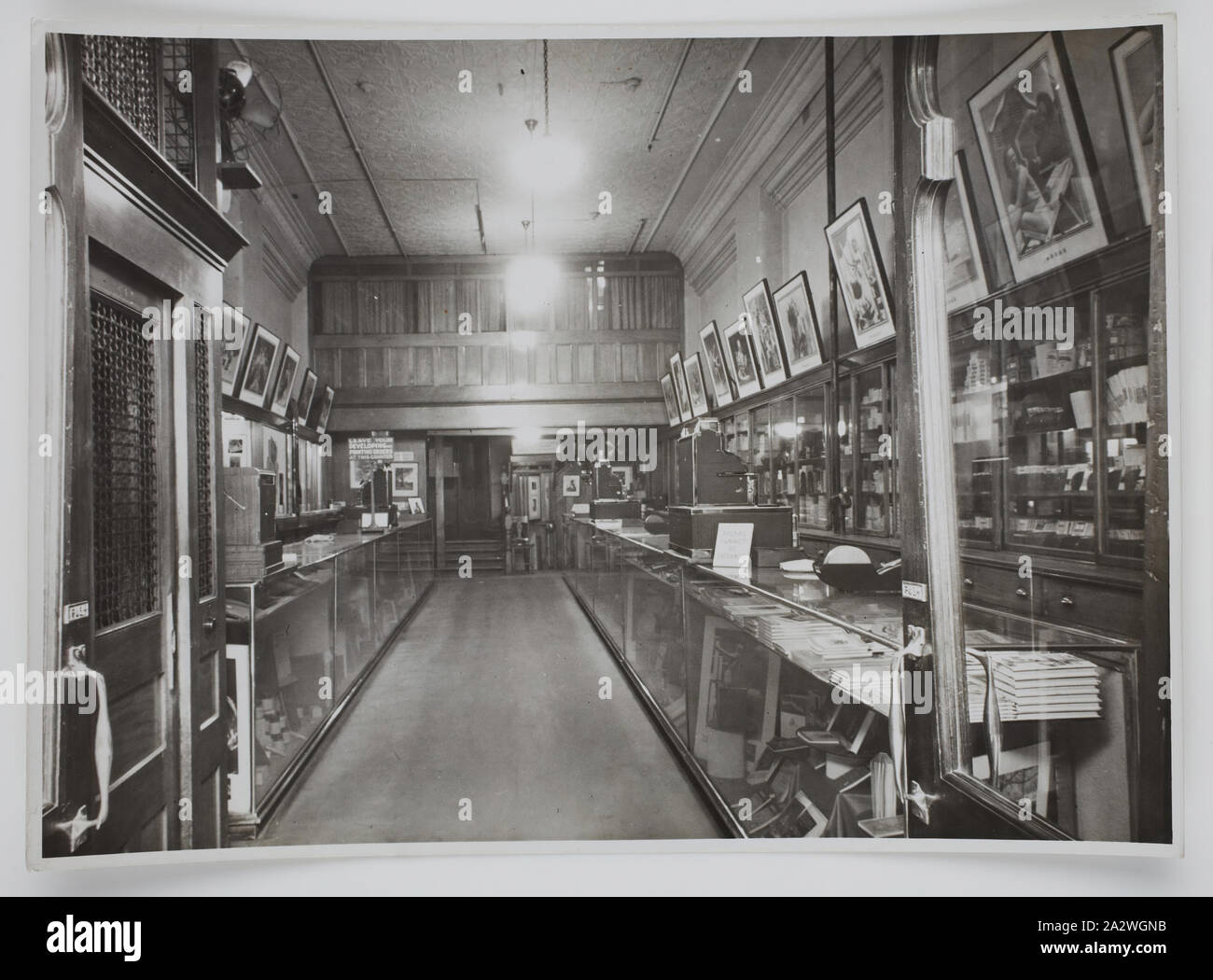 Photograph, Shop Interior, Sydney, New South Wales, circa 1940s, Black and white photograph of the interior of the Kodak Australasia Pty Ltd store in Sydney, New South Wales, circa 1950s. This view shows service counters on the left and right. There are products and posters arranged throughout the store, and a set of stairs at the rear of the room. collection of products, promotional materials, photographs and working life Stock Photo