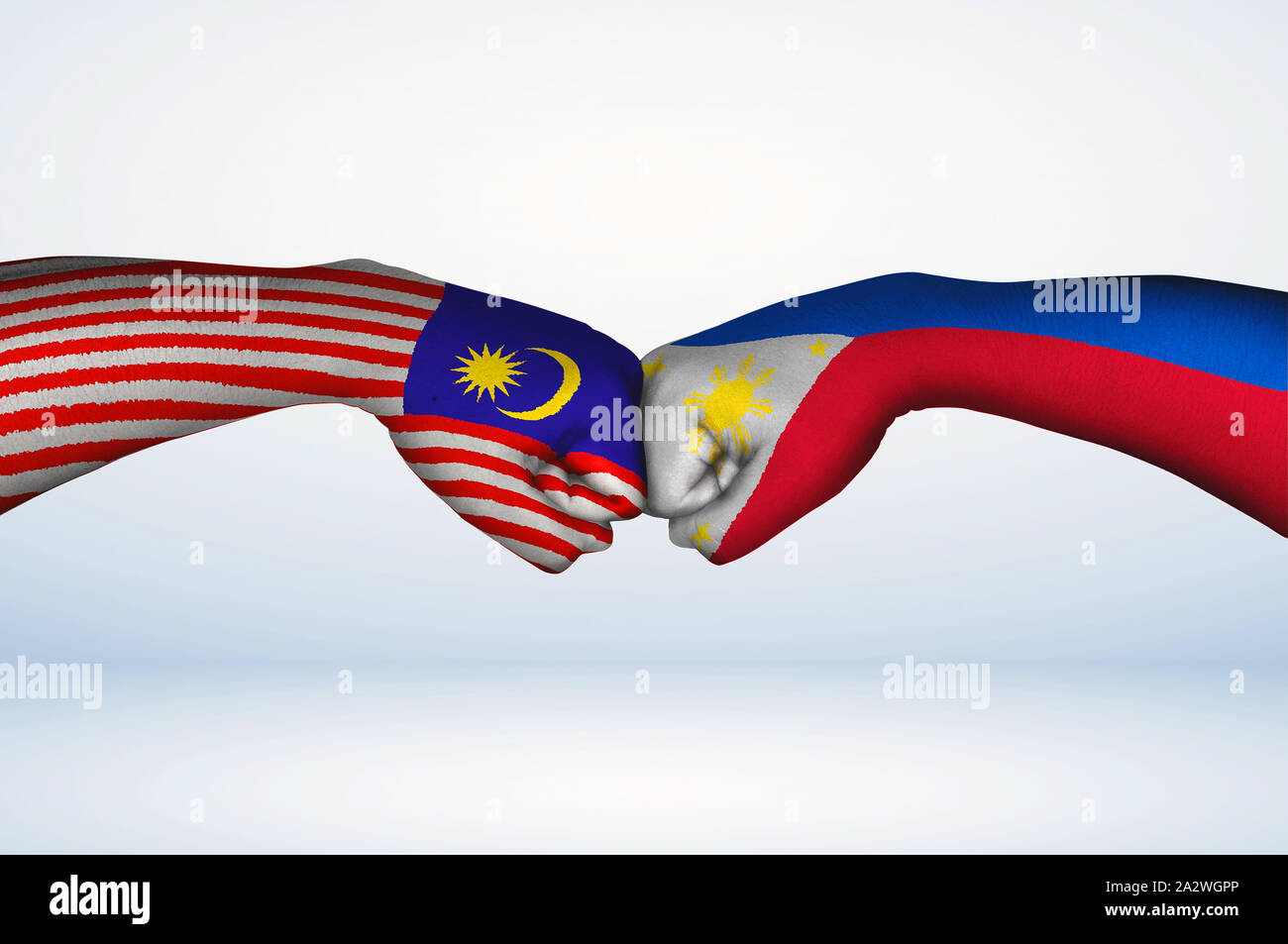 Fist bump of Malaysian and Filipino  flags. Two hands with painted flags of Malaysia and Philippines Flag fist bumping as a symbol of unity. Stock Photo