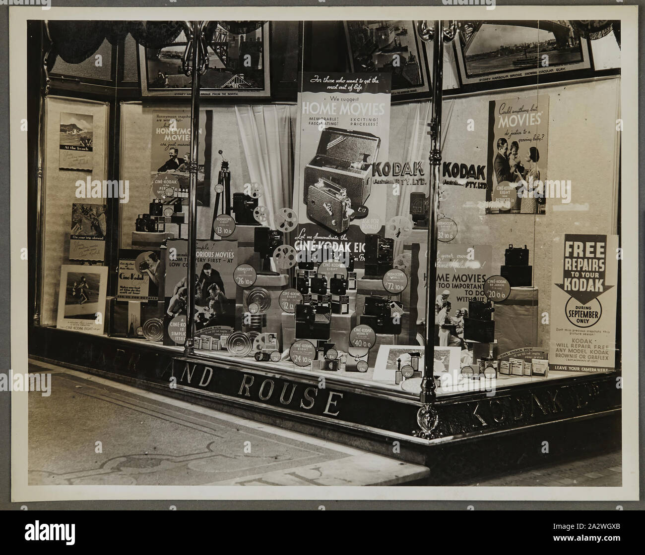 Photograph - Kodak, Shopfront Display, 'We Suggest Home Movies', circa 1934-1936, Shopfront display 'We Suggest Home Movies' showing movie cameras, photographs, photographic accessories and equipment. One of fifty-six photographs in an album depicting Kodak Australasia Pty Ltd shop front window displays from the mid-1930s. Windows generally featured product promotions for film or cameras, as well as photographic exhibitions to attract crowds to the store. Exhibitions featured Stock Photo