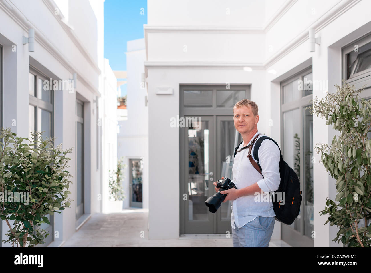 Man photographer taking pictures of Santorini, Greece. Shooting. Camera. Stock Photo