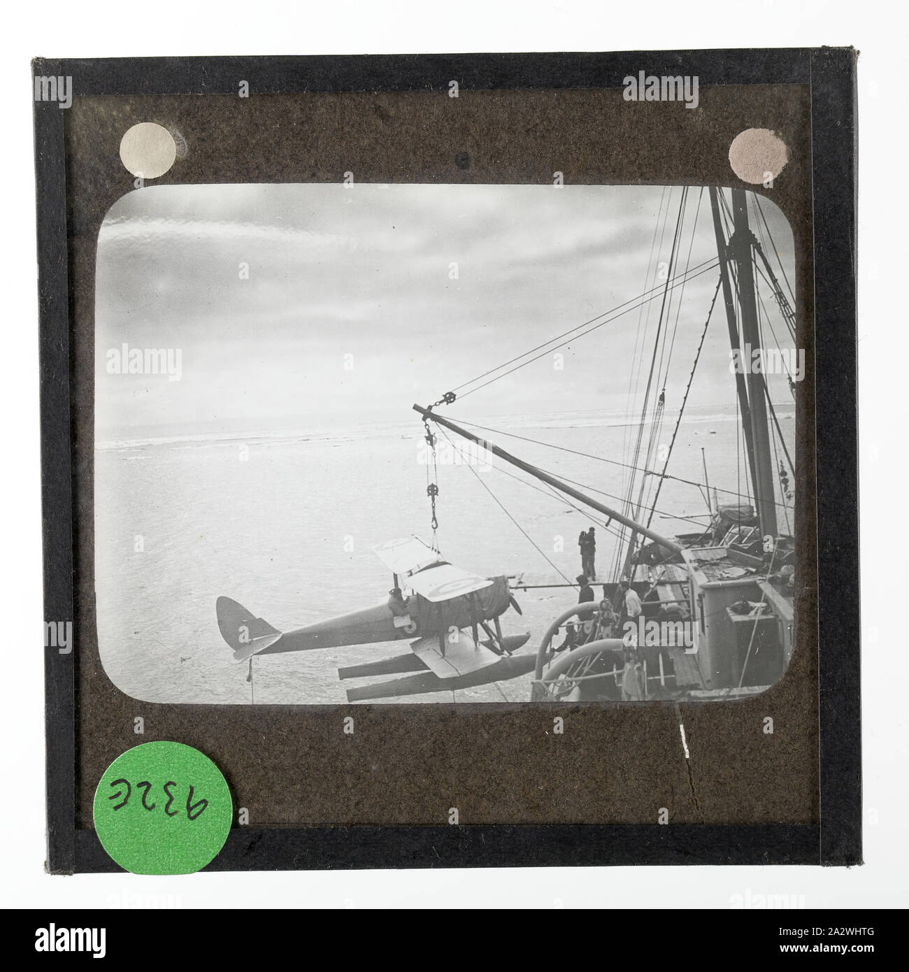Lantern Slide - Gipsy Moth A7-55 on the Lifting Hook, Ross Sea, Ellsworth Relief Expedition, Antarctica, 12 Jan 1936, Lantern slide of the Gipsy Moth A7-55 on the lifting hook of the Discovery II, Antarctica. One of 328 images in various formats including artworks, photographs, glass negatives and lantern slides Stock Photo